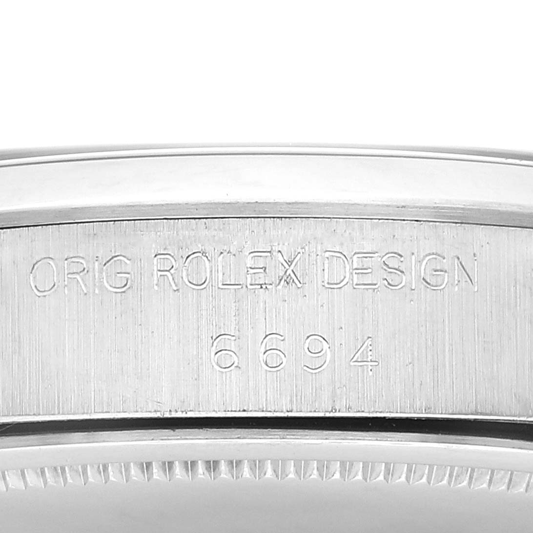 This image shows a close-up of the side case of the Vintage Collection Rolex watch, featuring the engraved inscription and model number 6694.