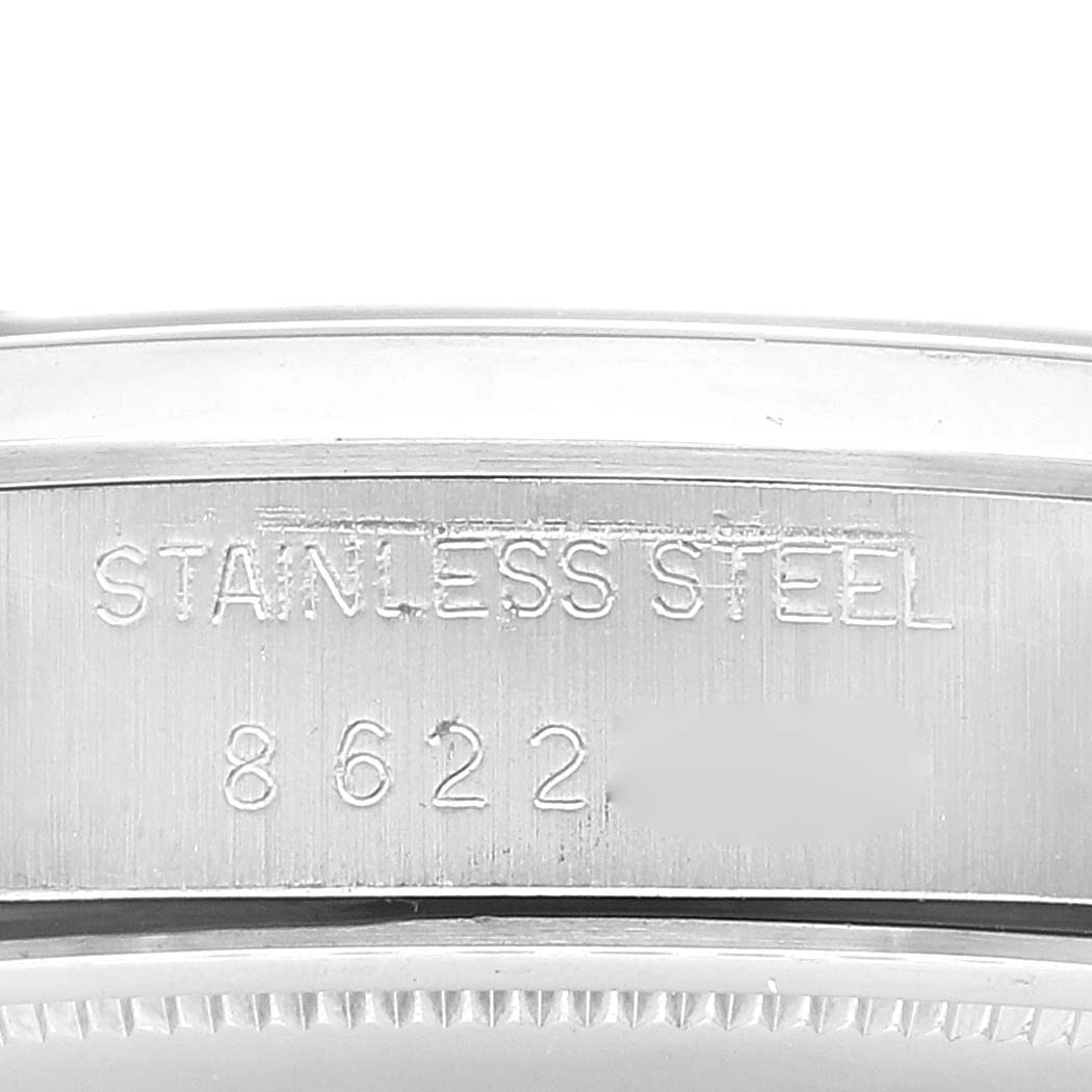 The image shows a close-up of the side of the bezel and case, revealing the text "STAINLESS STEEL" and serial number of a Rolex Vintage Collection 6694 Men's Stainless Steel Silver Dial 6694 Men's Stainless Steel Silver Dial model.