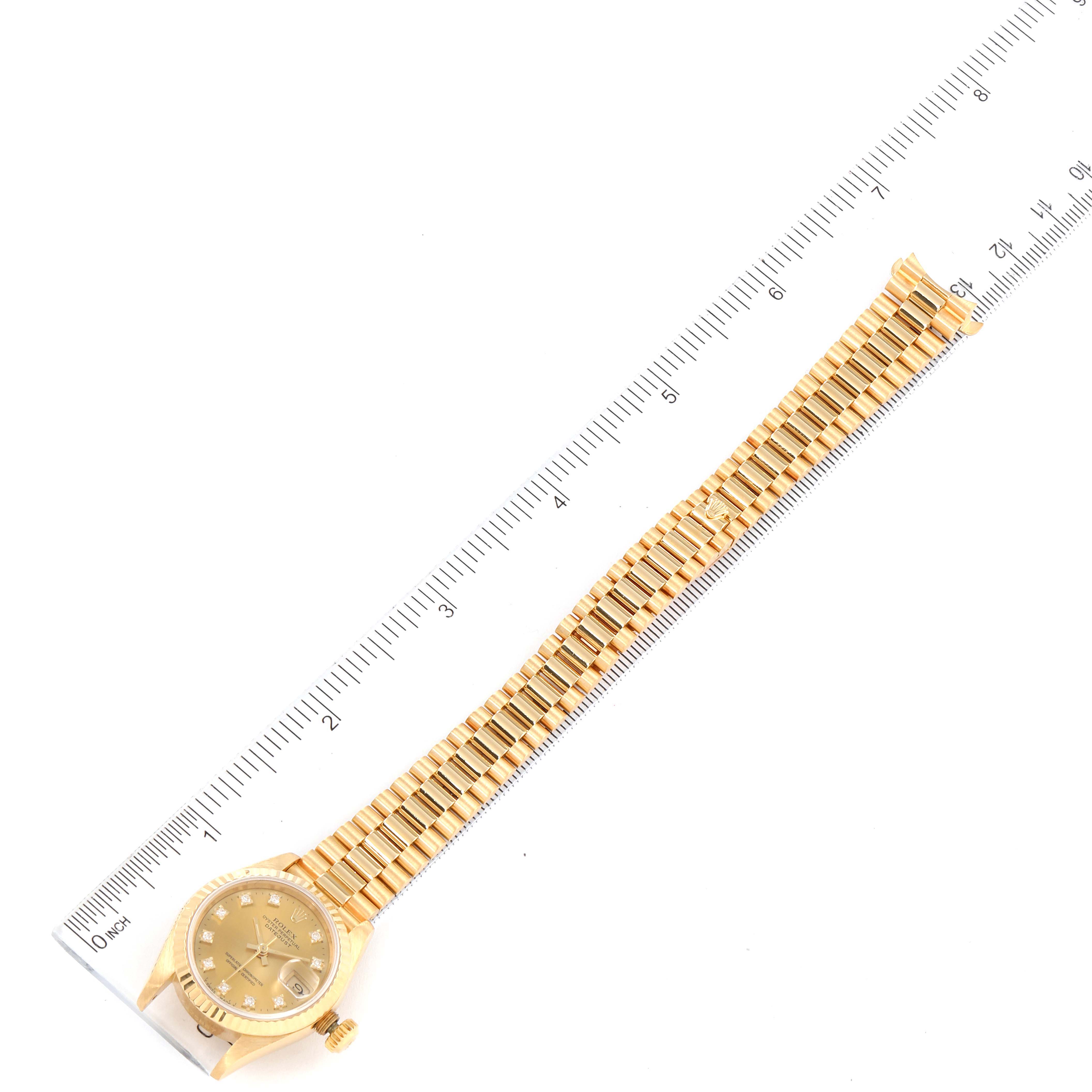 The image shows a top-down view of a Rolex President 69178 Women's Yellow Gold Champagne Dial 69178 Women's Yellow Gold Champagne Dial watch with its full gold bracelet placed next to a ruler.