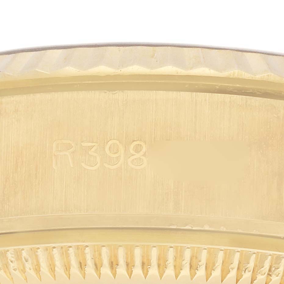 The image shows a close-up of the side of a Rolex President 69178 Women's Yellow Gold Champagne Dial 69178 Women's Yellow Gold Champagne Dial model, focusing on the serial number engraved on the gold case.