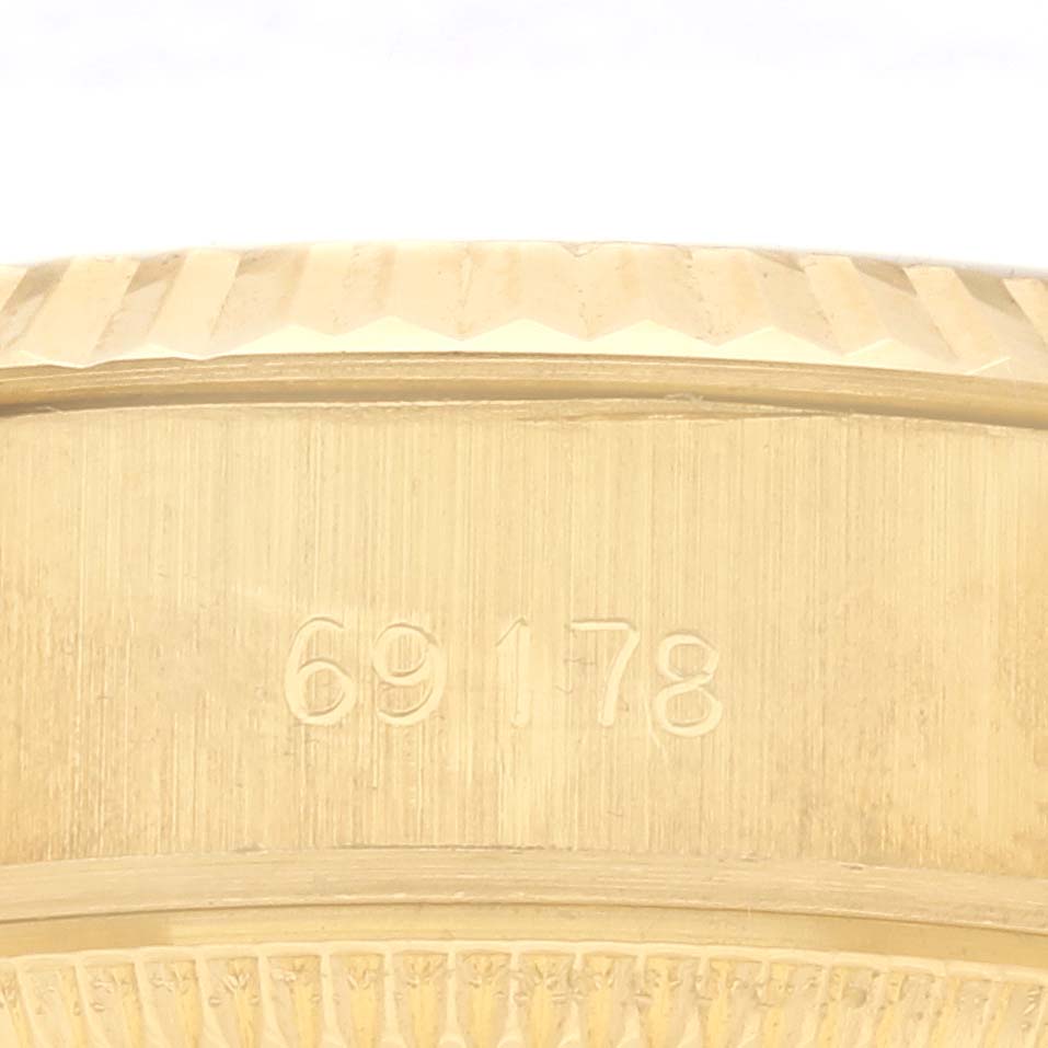 The image shows the side view of a Rolex President 69178 Women's Yellow Gold Champagne Dial 69178 Women's Yellow Gold Champagne Dial model watch, focusing on the edge with engraved numbers.