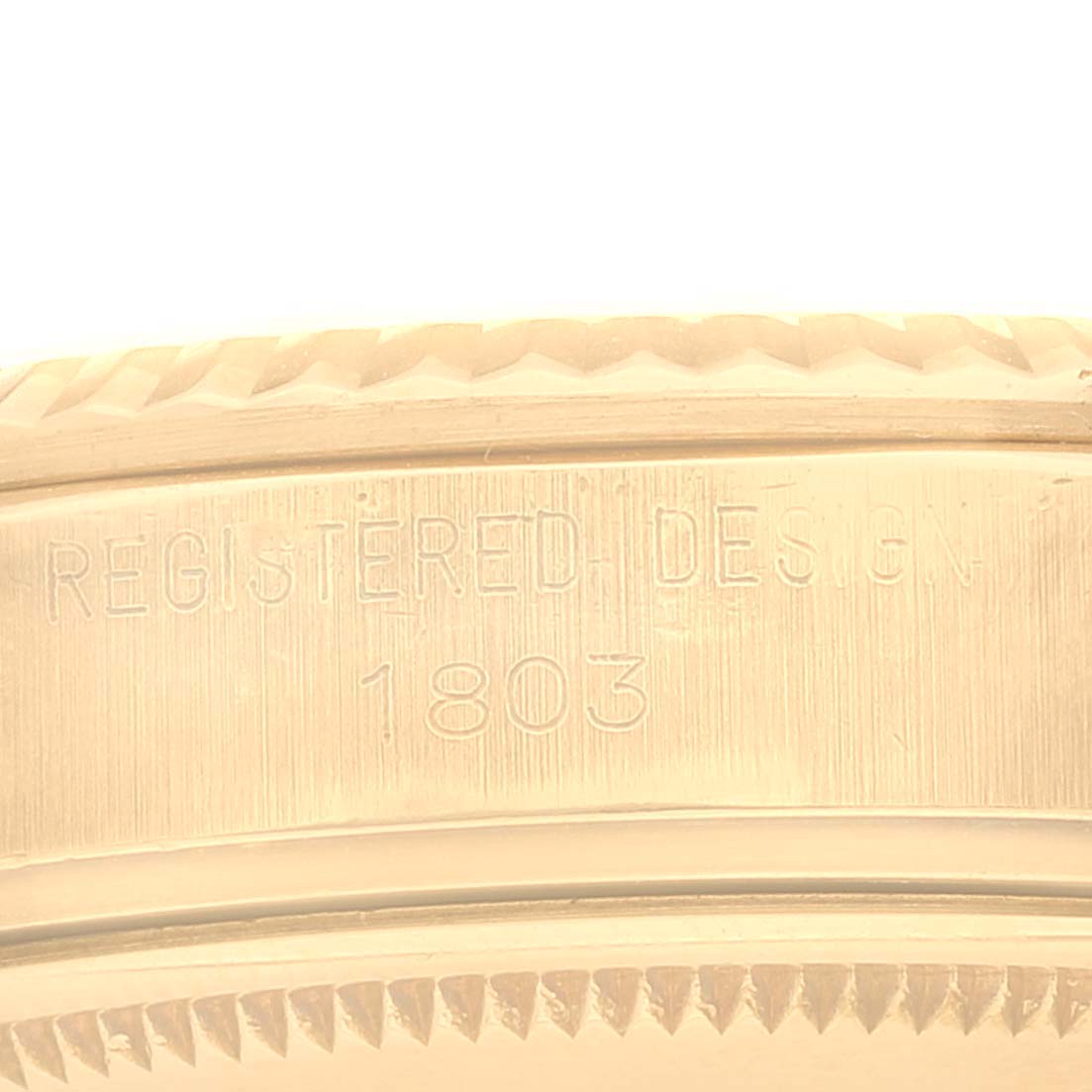 The image shows a close-up of the side of a Rolex President 1803 Men's Yellow Gold Champagne Dial 1803 Men's Yellow Gold Champagne Dial model watch, highlighting the engraved "Registered Design" and "1803".