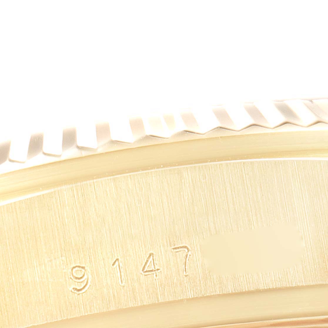 This close-up image shows a partial view of the bezel and case of the Rolex President 18038 Men's Yellow Gold Champagne Dial 18038 Men's Yellow Gold Champagne Dial model watch, including its engraved serial number.
