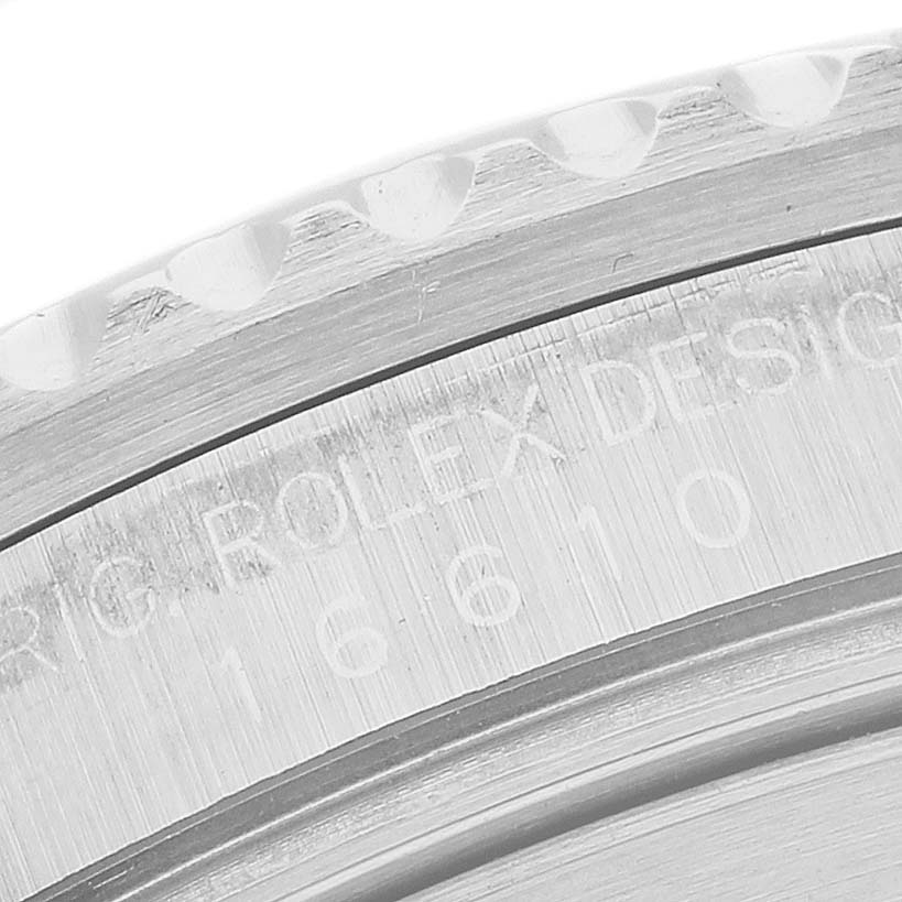 The image shows a close-up of the engraved edge of the Rolex Submariner 16610 Men's Stainless Steel Black Dial's case, highlighting the model number.