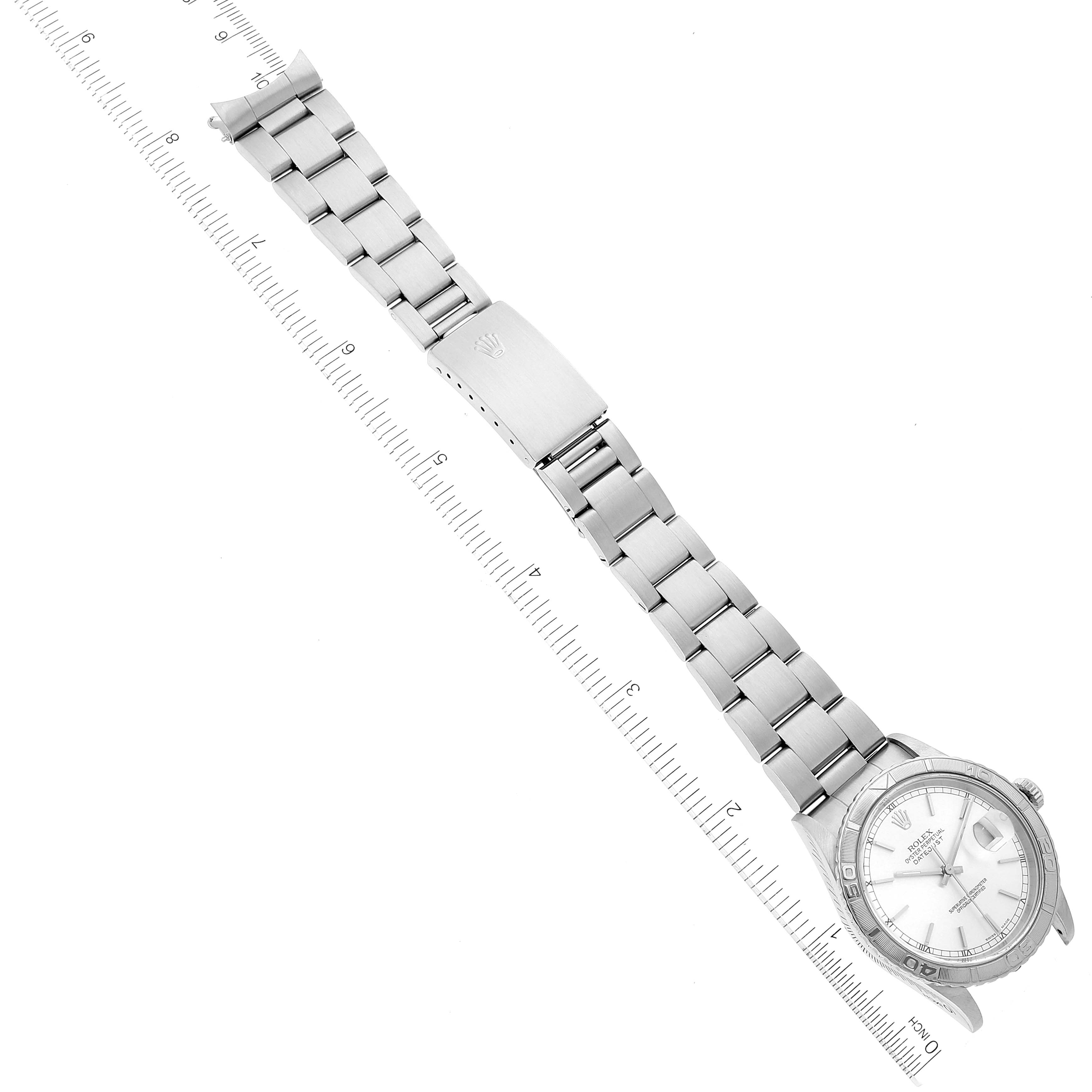 The image shows a Rolex Turn-o-Graph 16264 Men
s Stainless Steel Silver Dial 16264 Men
s Stainless Steel Silver Dial watch laid out flat with a ruler for scale, displaying the face, bezel, and metal bracelet.