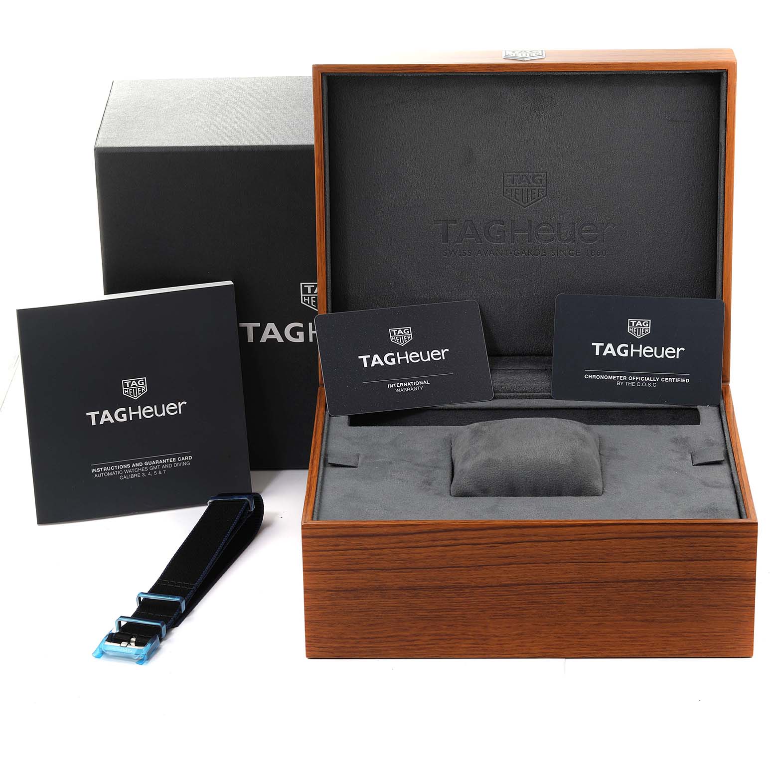 The image shows a Tag Heuer Autavia WBE5116.EB0173 Men's Stainless Steel Blue Dial WBE5116.EB0173 Men's Stainless Steel Blue Dial watch box with warranty cards, documentation, and an additional black strap.