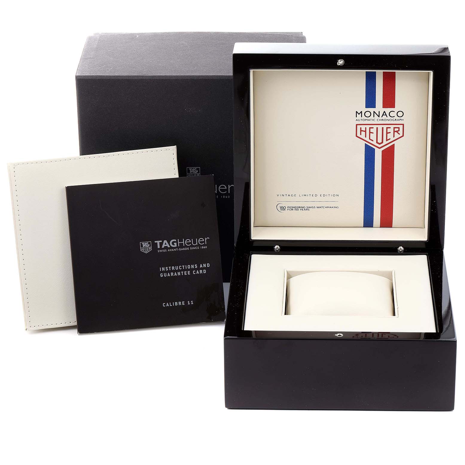 The image shows the Tag Heuer Monaco watch box, instruction manuals, and guarantee card from a front angle.