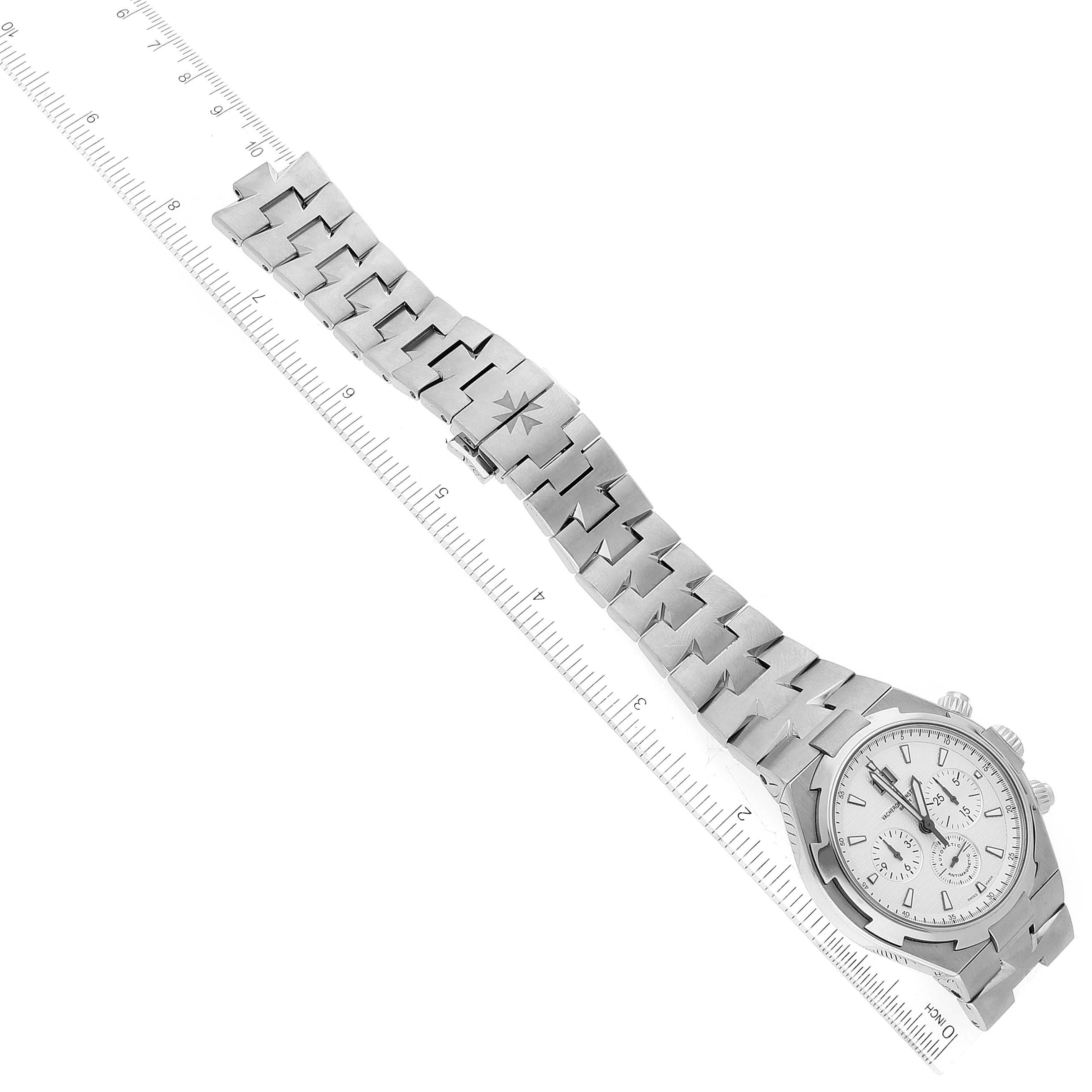 The Vacheron Constantin Overseas 49150/B01A-9095 Men
s Stainless Steel Silver Dial 49150/B01A-9095 Men
s Stainless Steel Silver Dial watch is shown from an overhead angle, displaying the dial and full length of the bracelet alongside a ruler for scale.