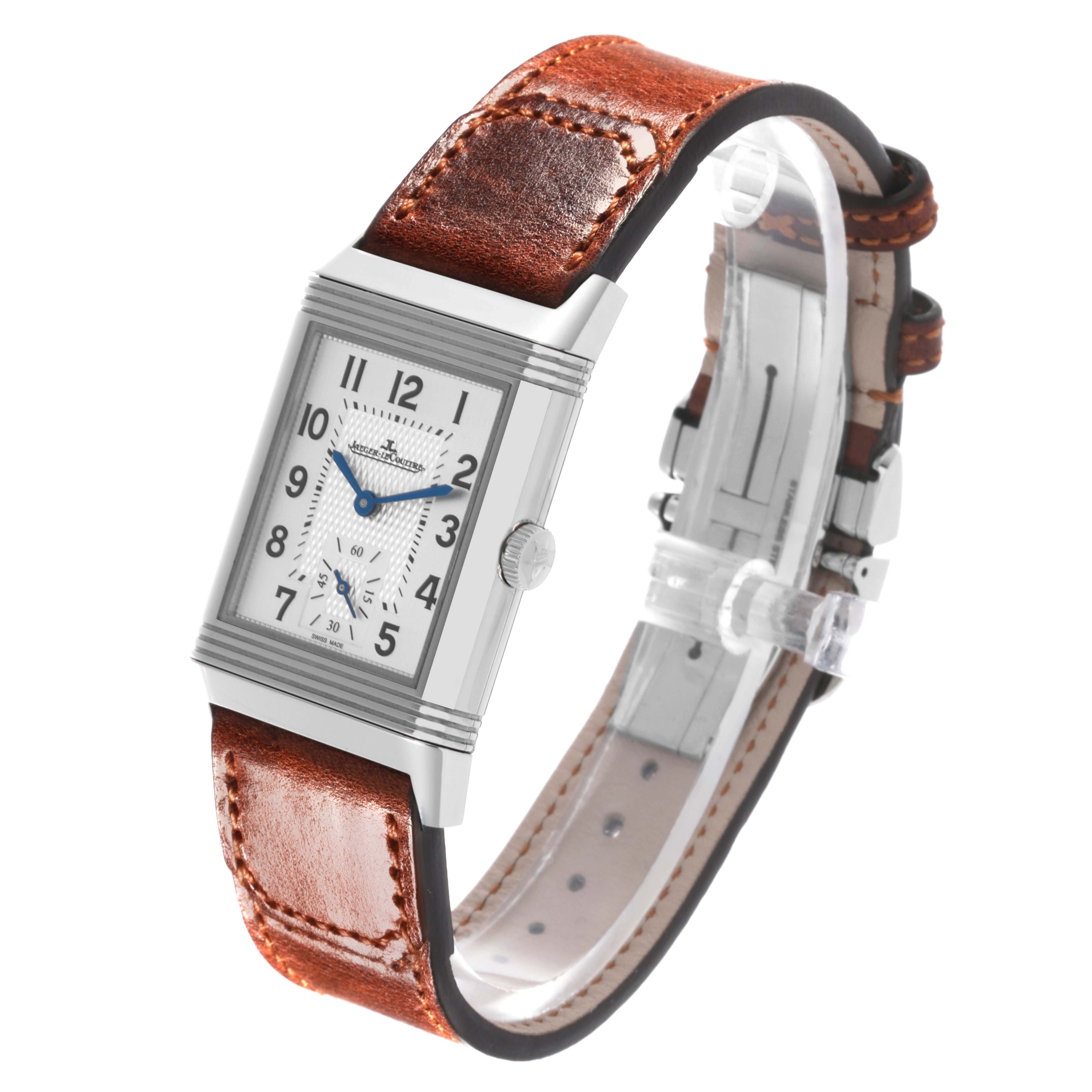 The Jaeger-LeCoultre Reverso watch is shown at a slight angle, displaying the face, crown, and brown leather strap.