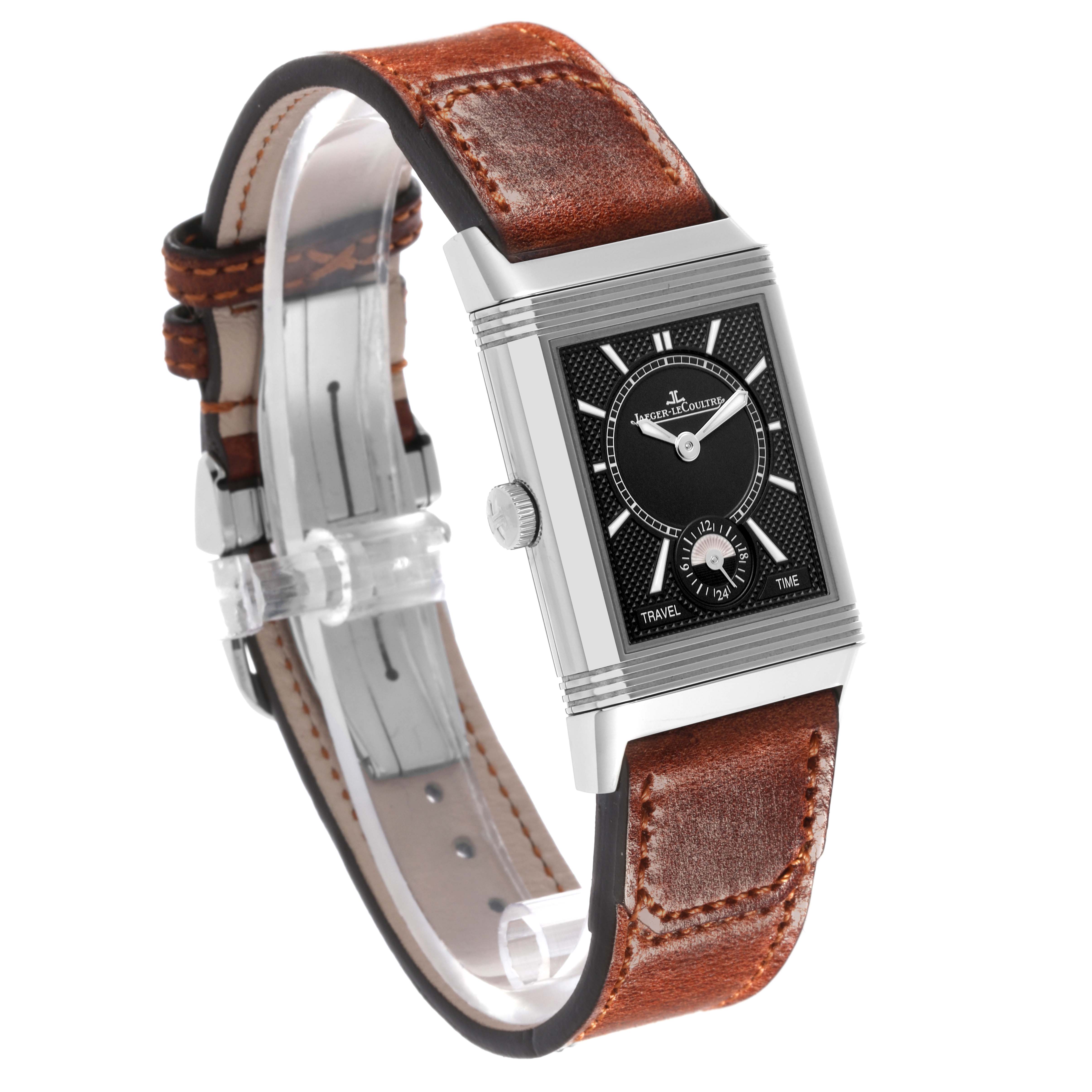 The Jaeger-LeCoultre Reverso watch is shown at an angle, displaying its dial, crown, and brown leather strap.
