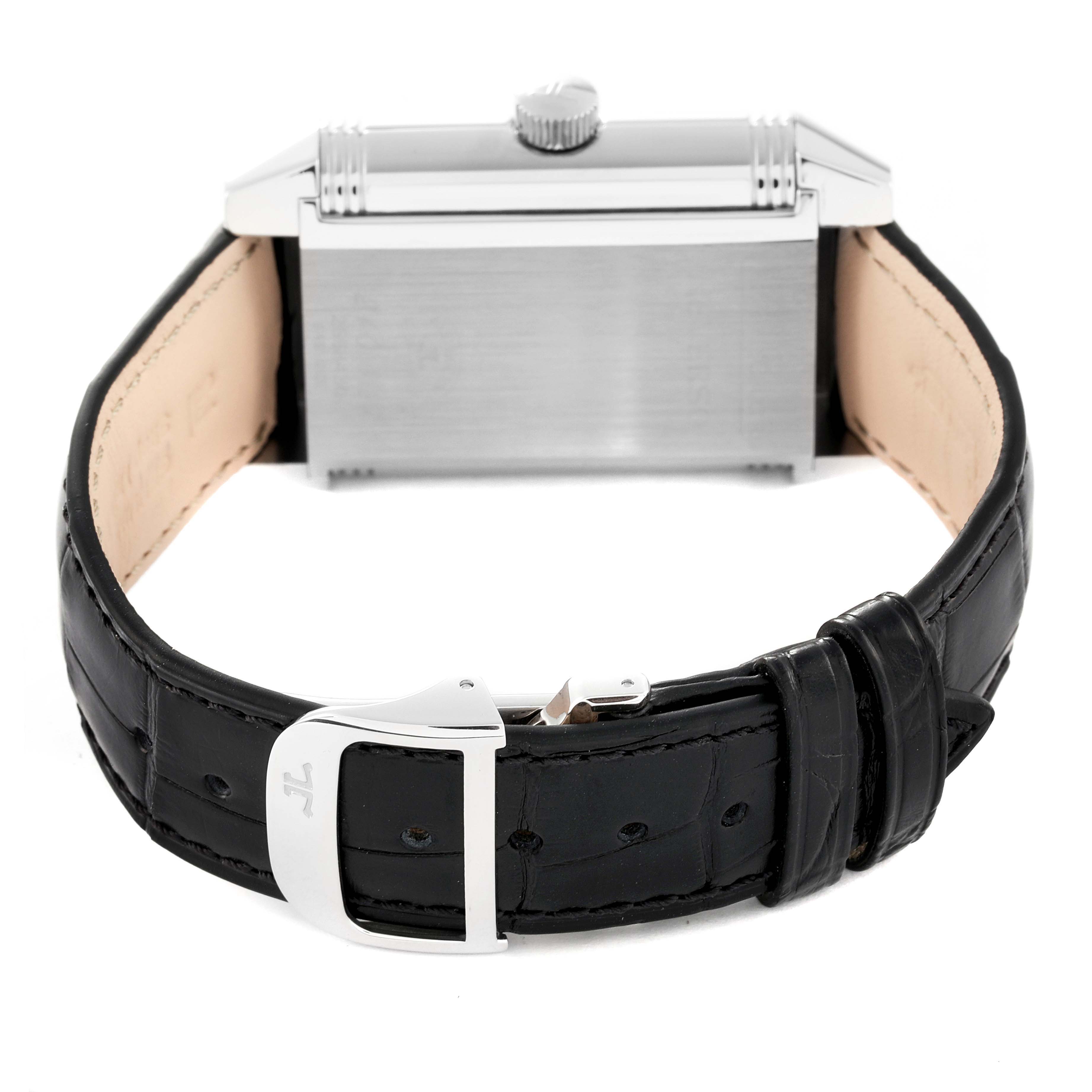 The image shows the back view of a Jaeger-LeCoultre Reverso watch, highlighting the watch case, crown, and black leather strap with the clasp.