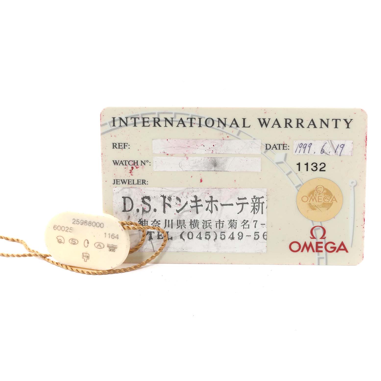 The image shows an Omega Seamaster 2598.80.00 Men's Stainless Steel Blue Dial 2598.80.00 Men's Stainless Steel Blue Dial international warranty card dated 1999, alongside a tag with reference numbers.