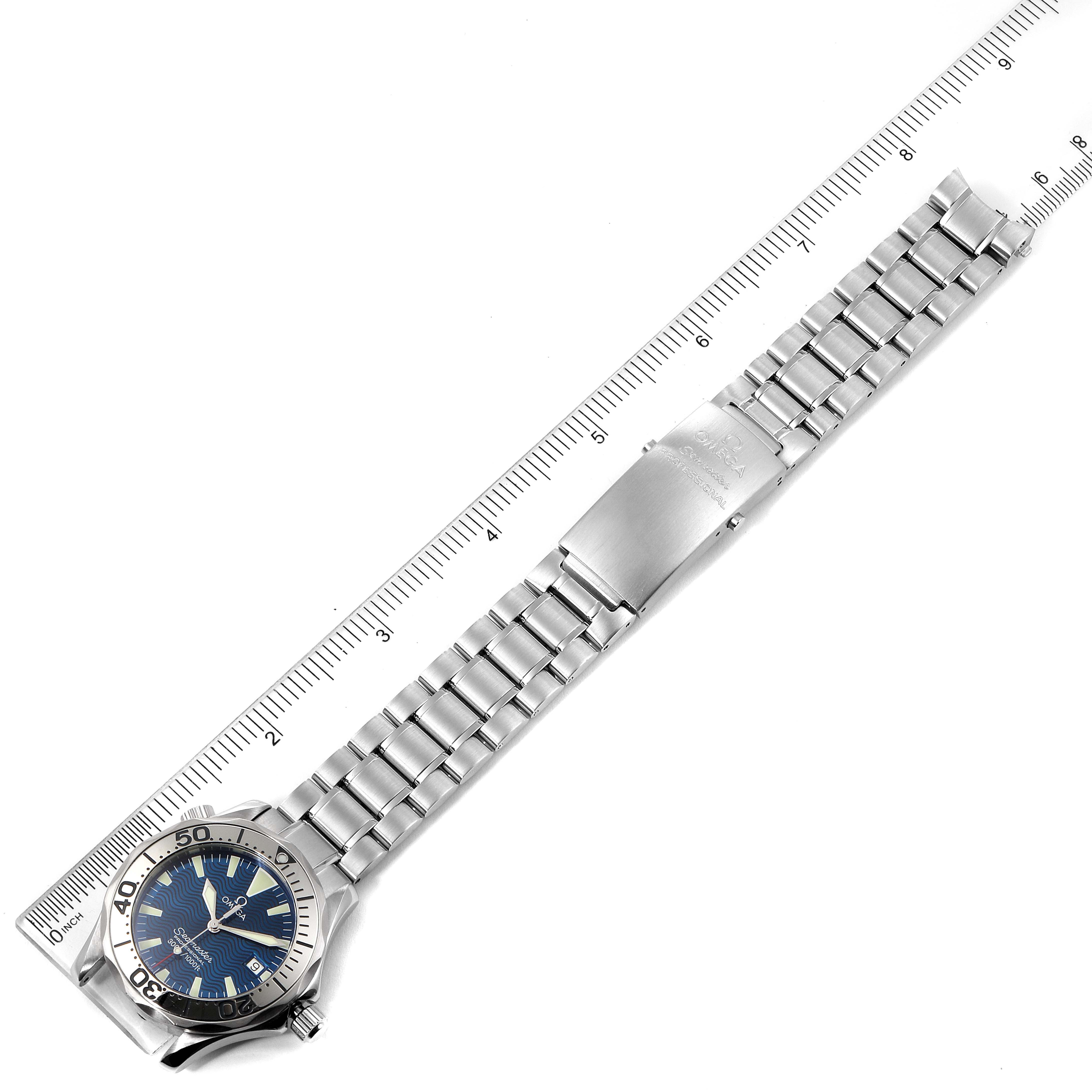 The image shows a top-down view of an Omega Seamaster 2263.80.00 Men's Stainless Steel Blue Dial 2263.80.00 Men's Stainless Steel Blue Dial watch with a metal bracelet placed alongside a ruler for scale.