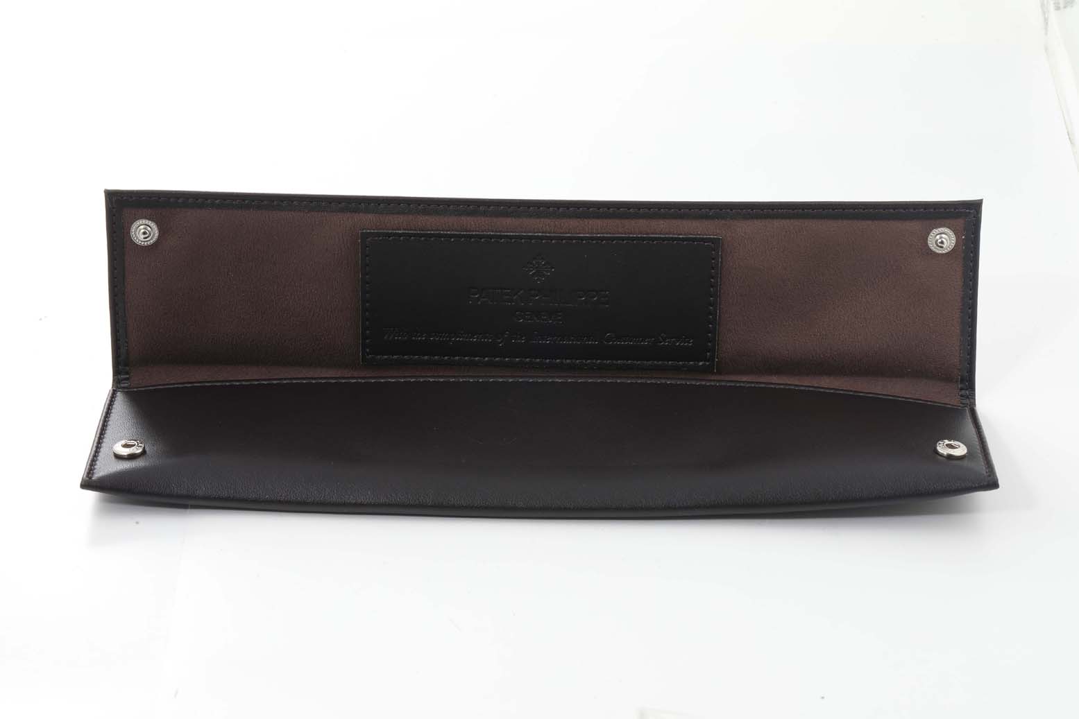 This image shows an opened leather pouch for the Calatrava model by Patek Philippe from a top-down angle.