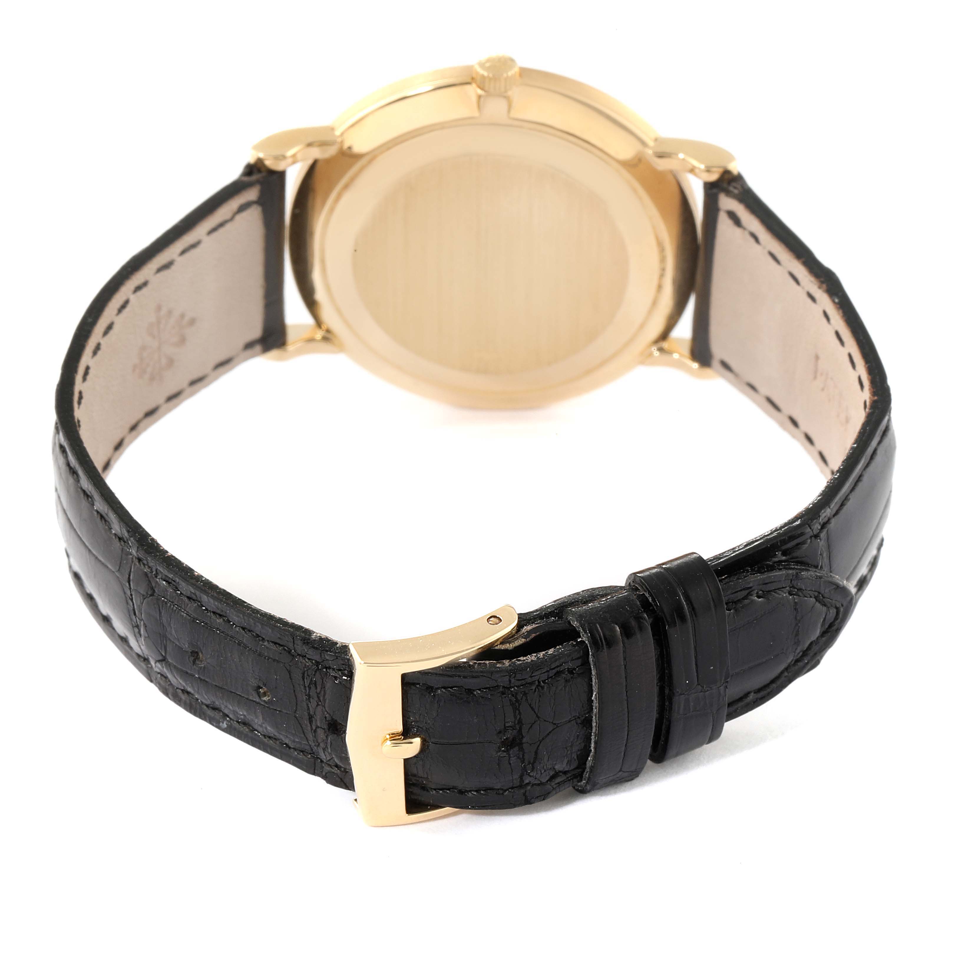 The image shows the back view of a Patek Philippe Calatrava 3919 Men's Yellow Gold White Dial 3919 Men's Yellow Gold White Dial watch with its black leather strap and gold clasp.