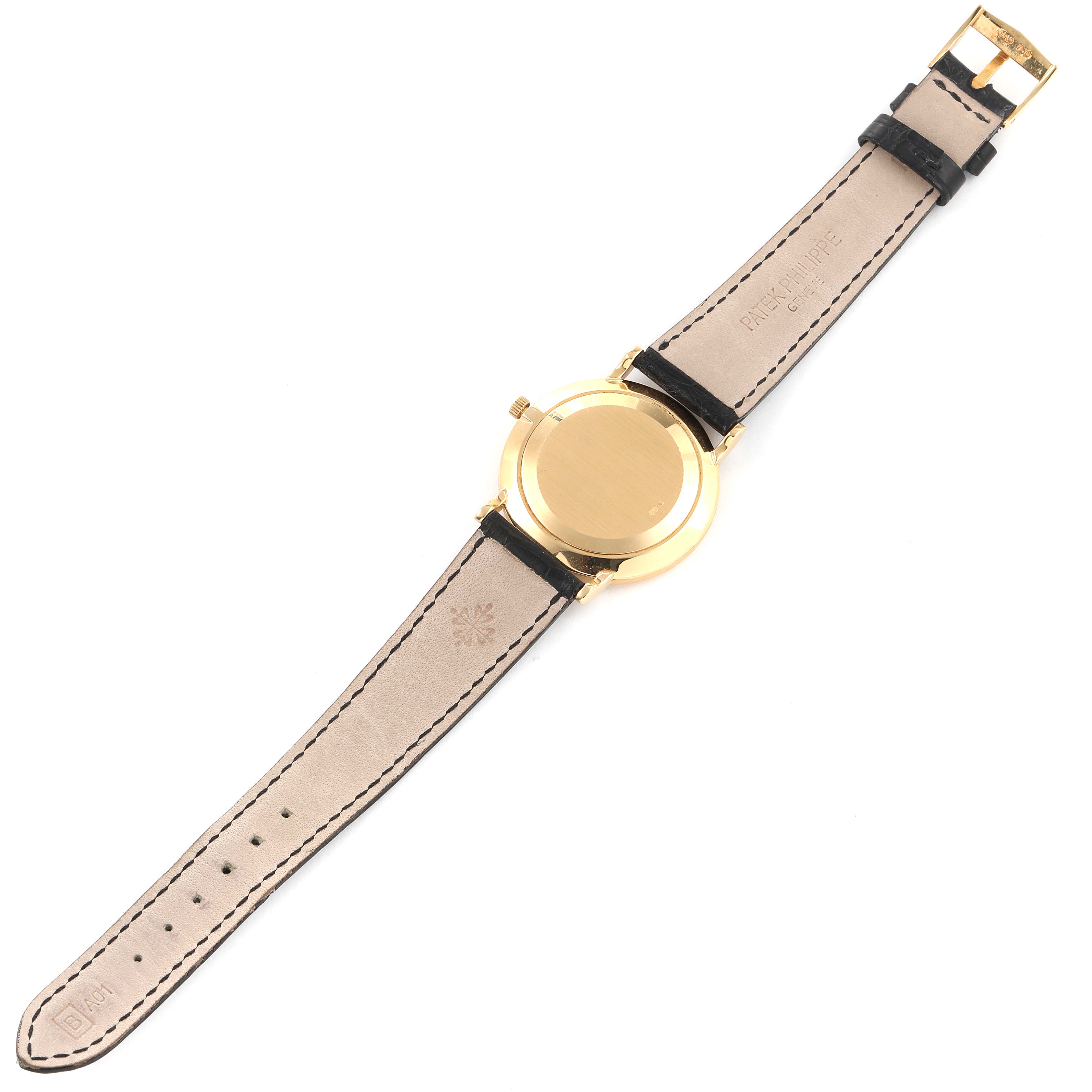 This image shows the back view of a Calatrava model watch by Patek Philippe, displaying the leather strap and gold case.