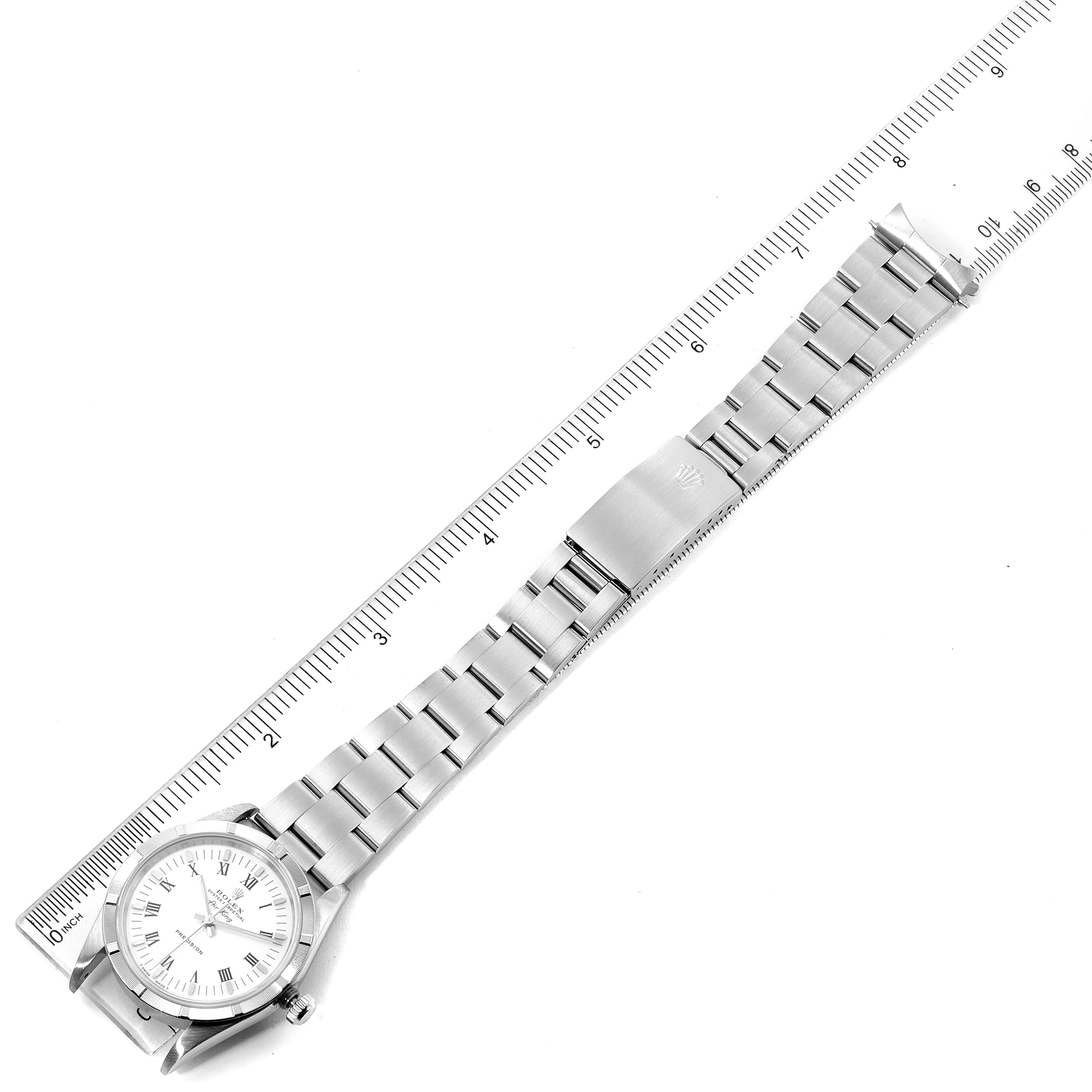 This image shows an overhead view of the Rolex Air-King 30891 Men's Stainless Steel White Dial 30891 Men's Stainless Steel White Dial watch, displaying the face, bracelet, and clasp alongside a ruler for scale.