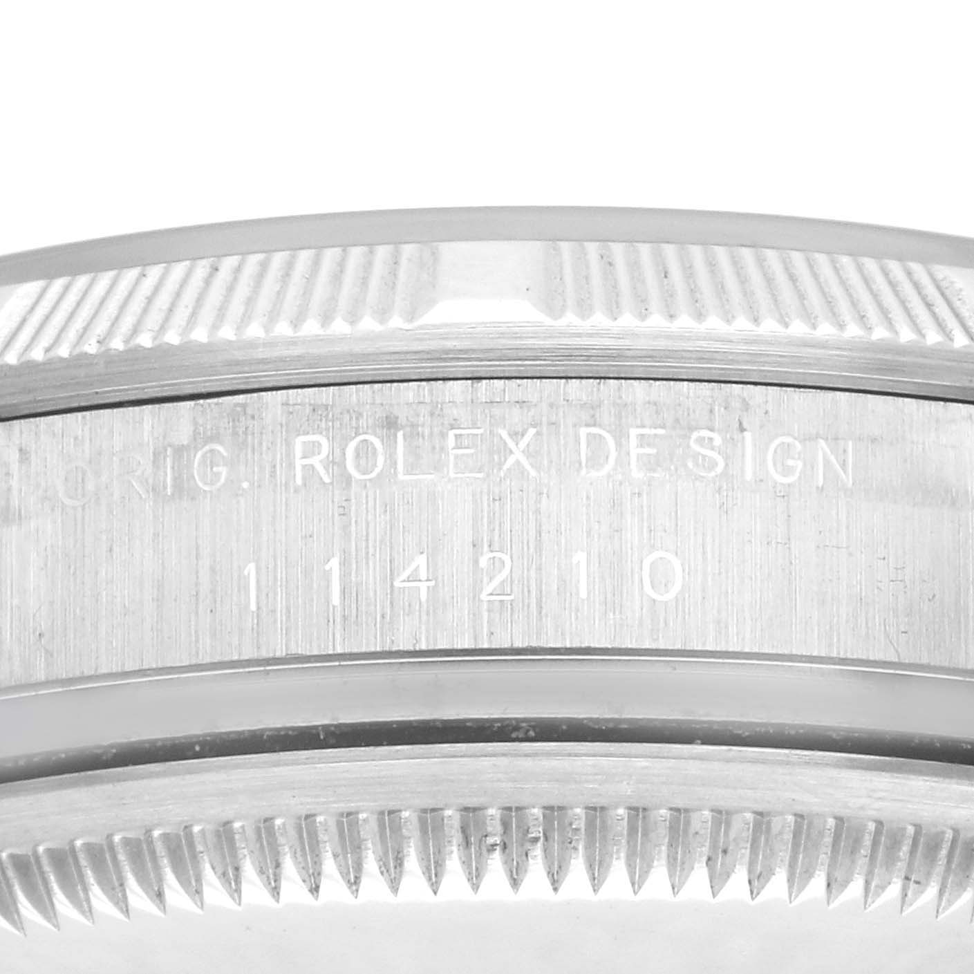 The image shows the side of a Rolex Air-King 114210 Men's Stainless Steel Silver Dial 114210 Men's Stainless Steel Silver Dial watch case with the model number and "ROLEX DESIGN" engraving.