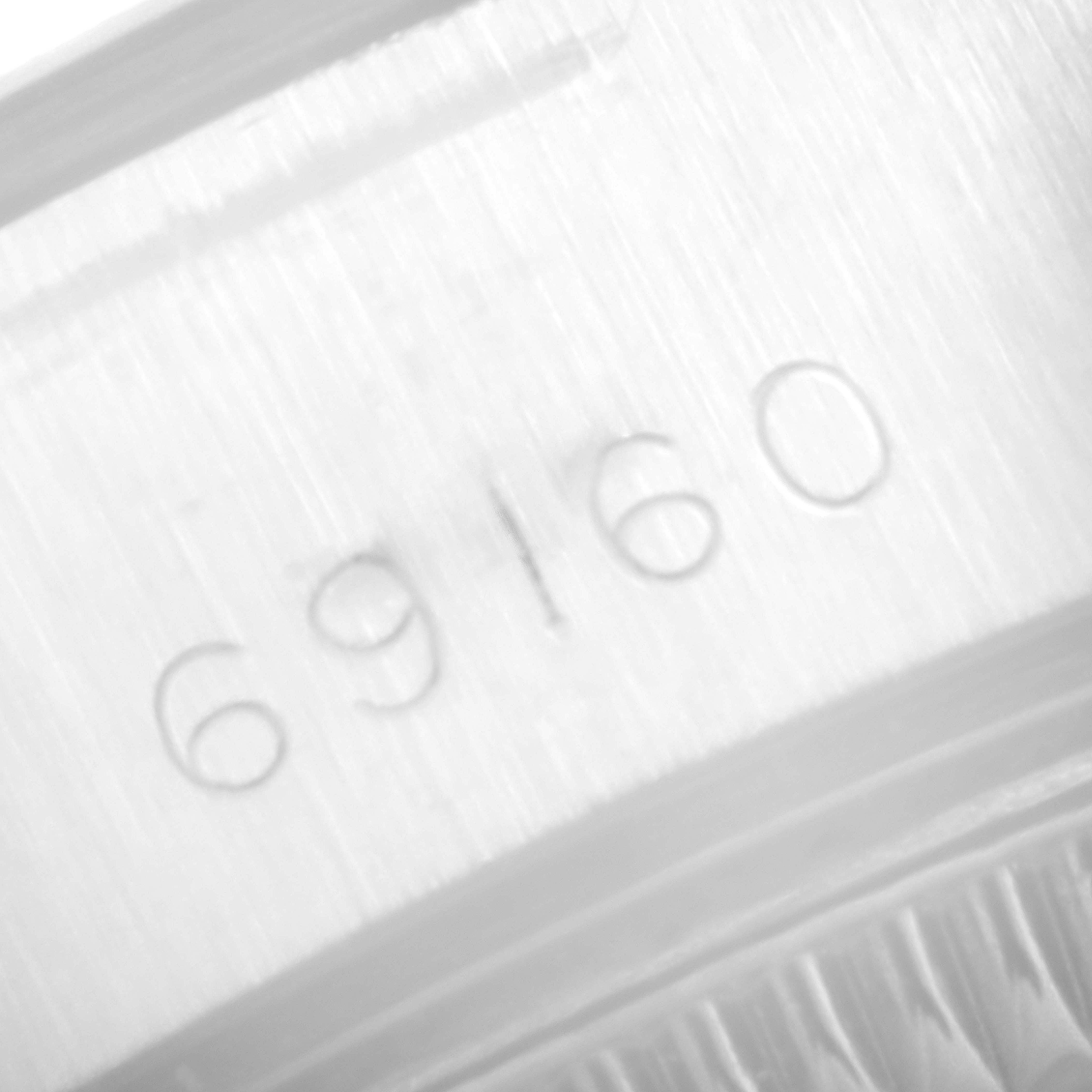 This image shows the engraved serial number "69160" on the case of a Rolex Date 69160 Women's Stainless Steel Blue Dial 69160 Women's Stainless Steel Blue Dial model watch.