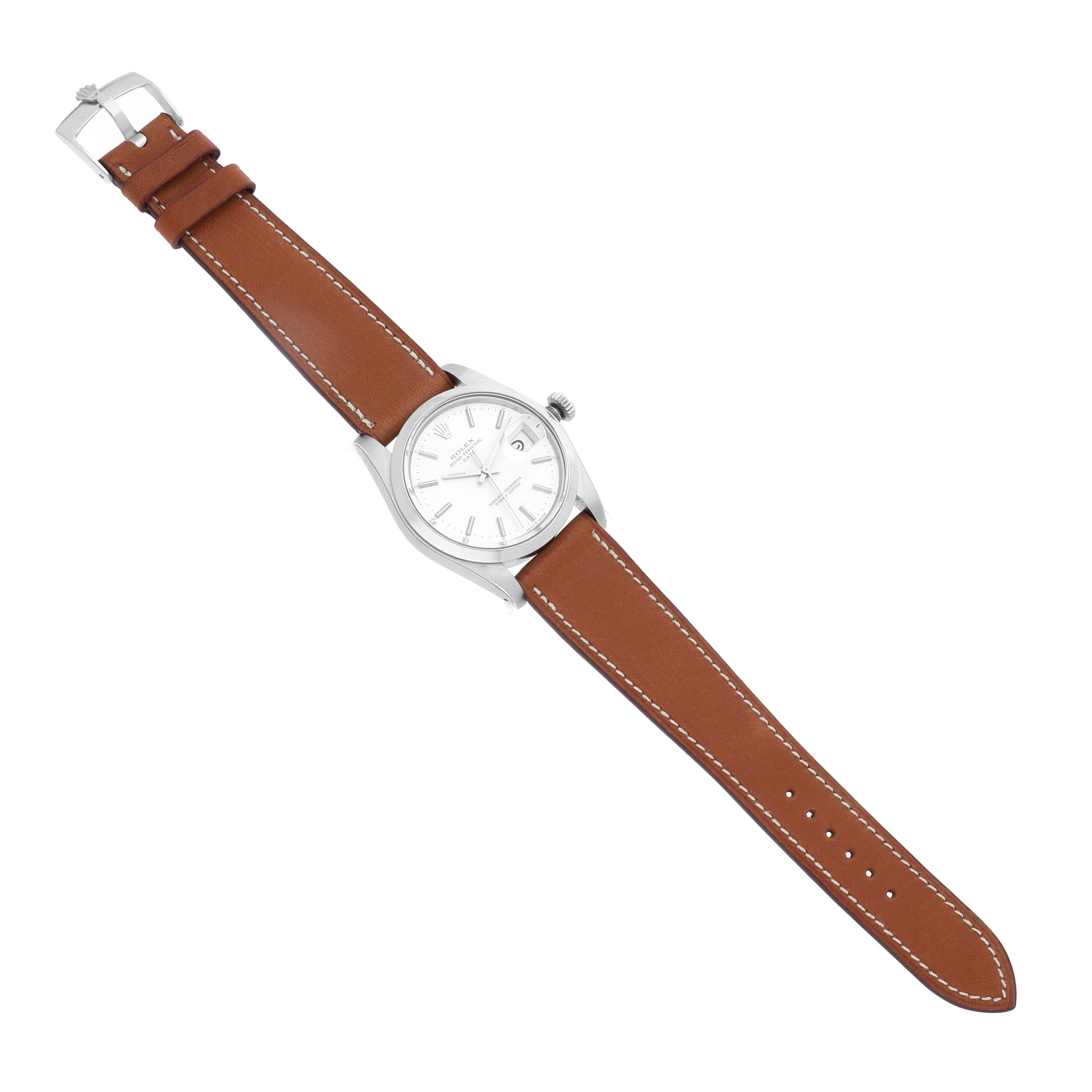 The Rolex Date 1500 Men's Stainless Steel Silver Dial 1500 Men's Stainless Steel Silver Dial watch is shown from a top-down angle, featuring the dial, case, crown, and brown leather strap.