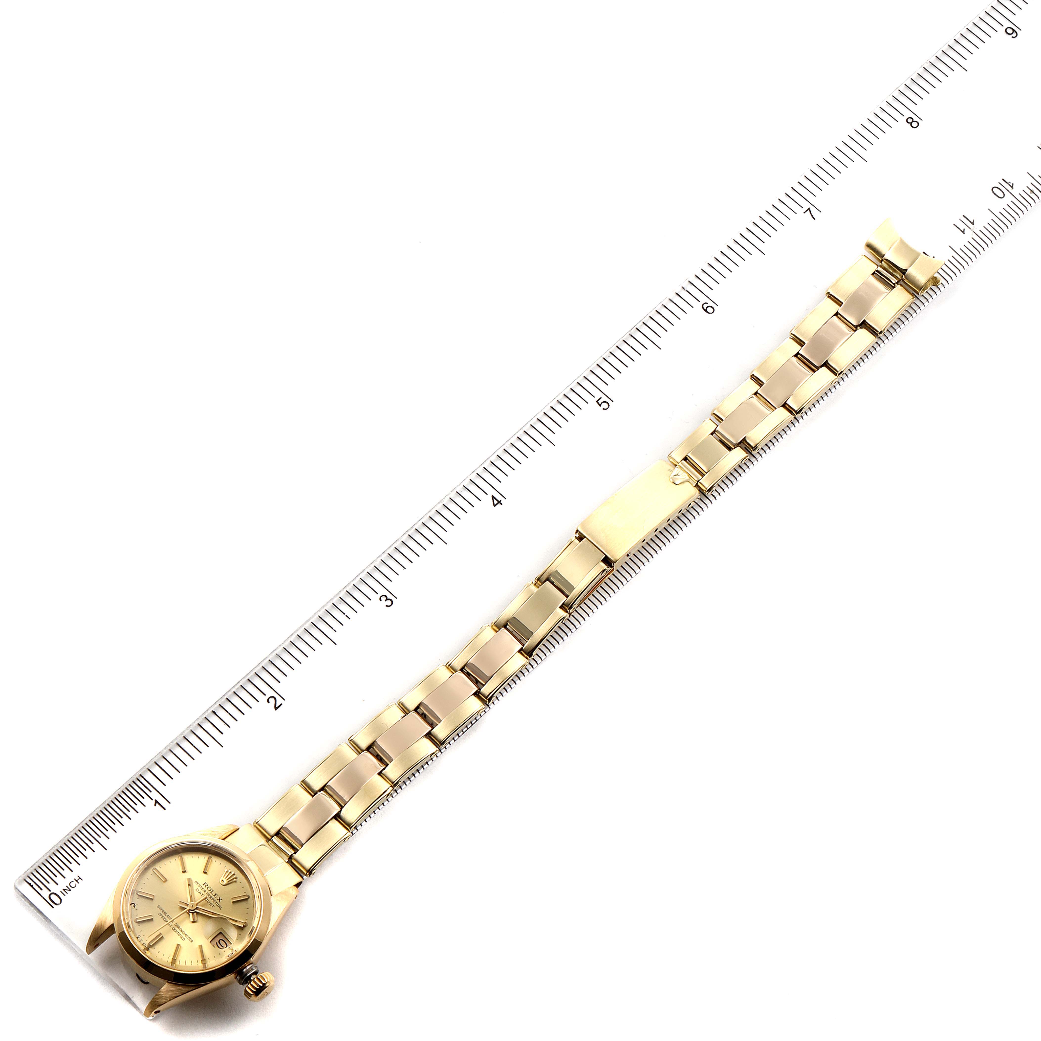 This image shows the Rolex President 6916 Women's Yellow Gold Champagne Dial 6916 Women's Yellow Gold Champagne Dial model watch laid flat next to a ruler for scale.