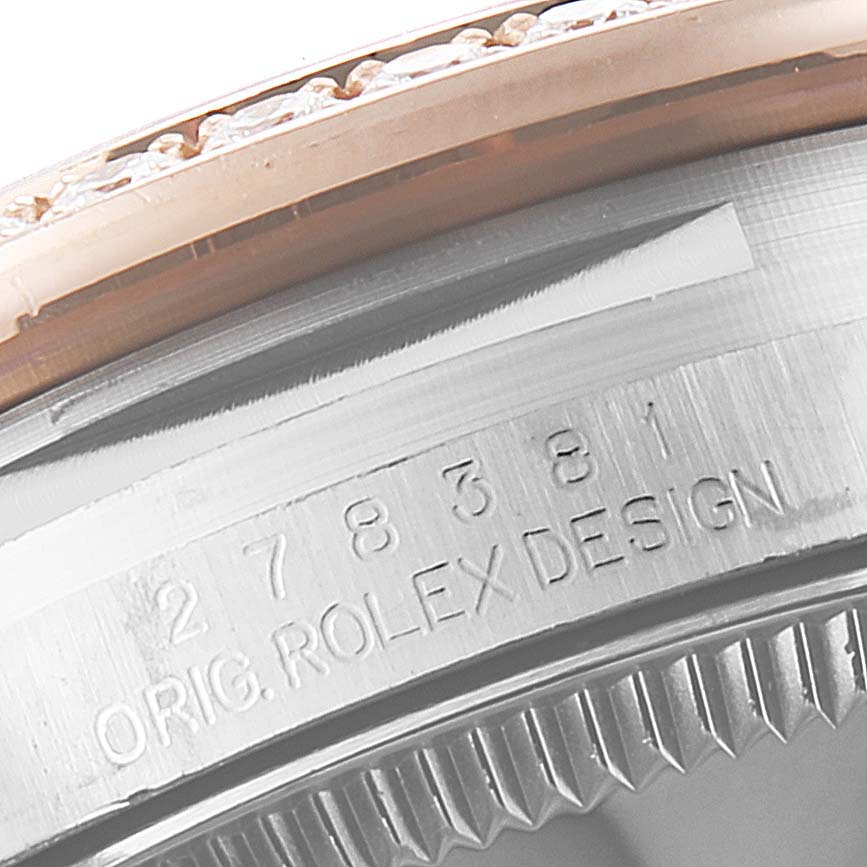 Close-up of a Mid-Size Rolex watch, showing the engraved serial number and the "ROLEX DESIGN" text.