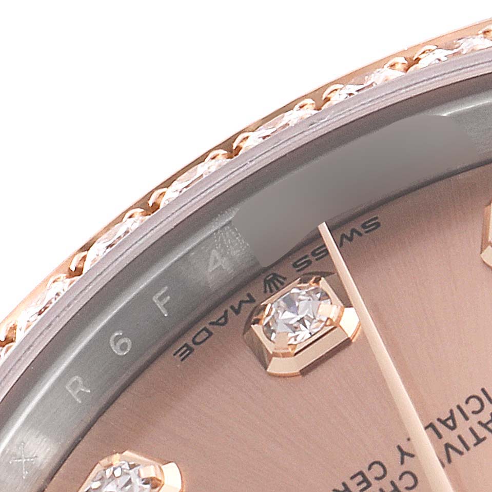 This close-up image shows the bezel, dial, and part of the face of a Mid-Size Rolex watch.