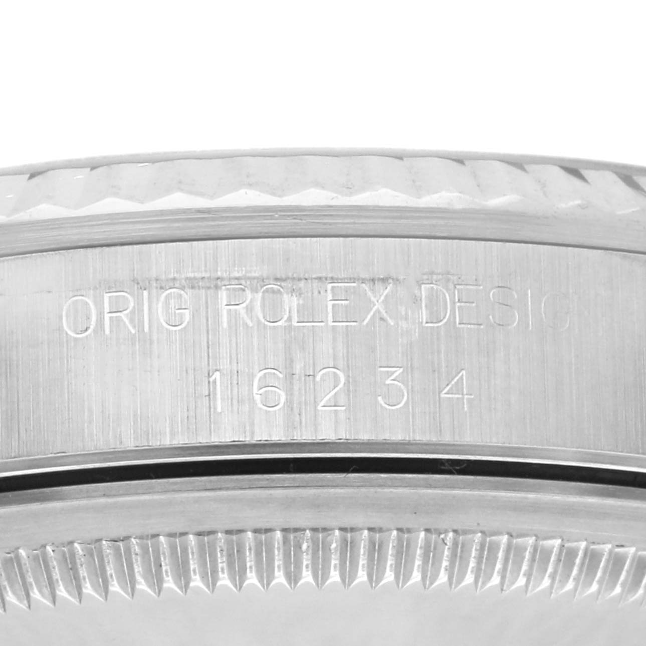 The image shows a close-up of the side of the Rolex Datejust 16234 Men's Stainless Steel Blue Dial 16234 Men's Stainless Steel Blue Dial model, featuring engraved details and part of the bezel.