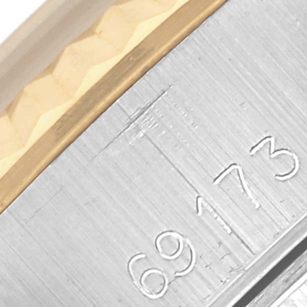 The image shows a close-up of the Rolex Datejust 69173 Women's Steel and Gold (two tone) Black Dial 69173 Women's Steel and Gold (two tone) Black Dial's bezel and serial engraving, highlighting the gold and silver tones.