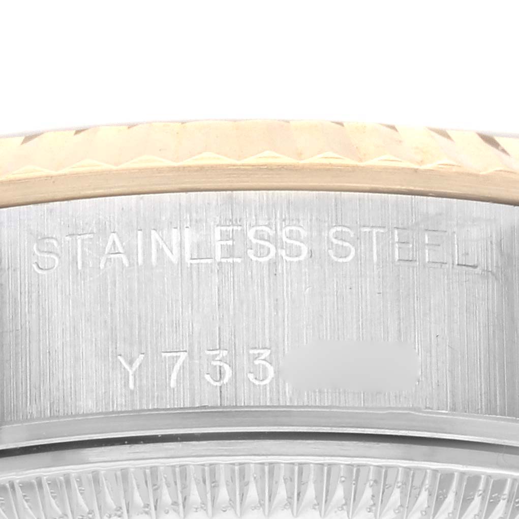 The image shows a close-up of the Rolex Datejust 79173 Women's Steel and Gold (two tone) Champagne Dial 79173 Women's Steel and Gold (two tone) Champagne Dial's bezel and engraved stainless steel case side.