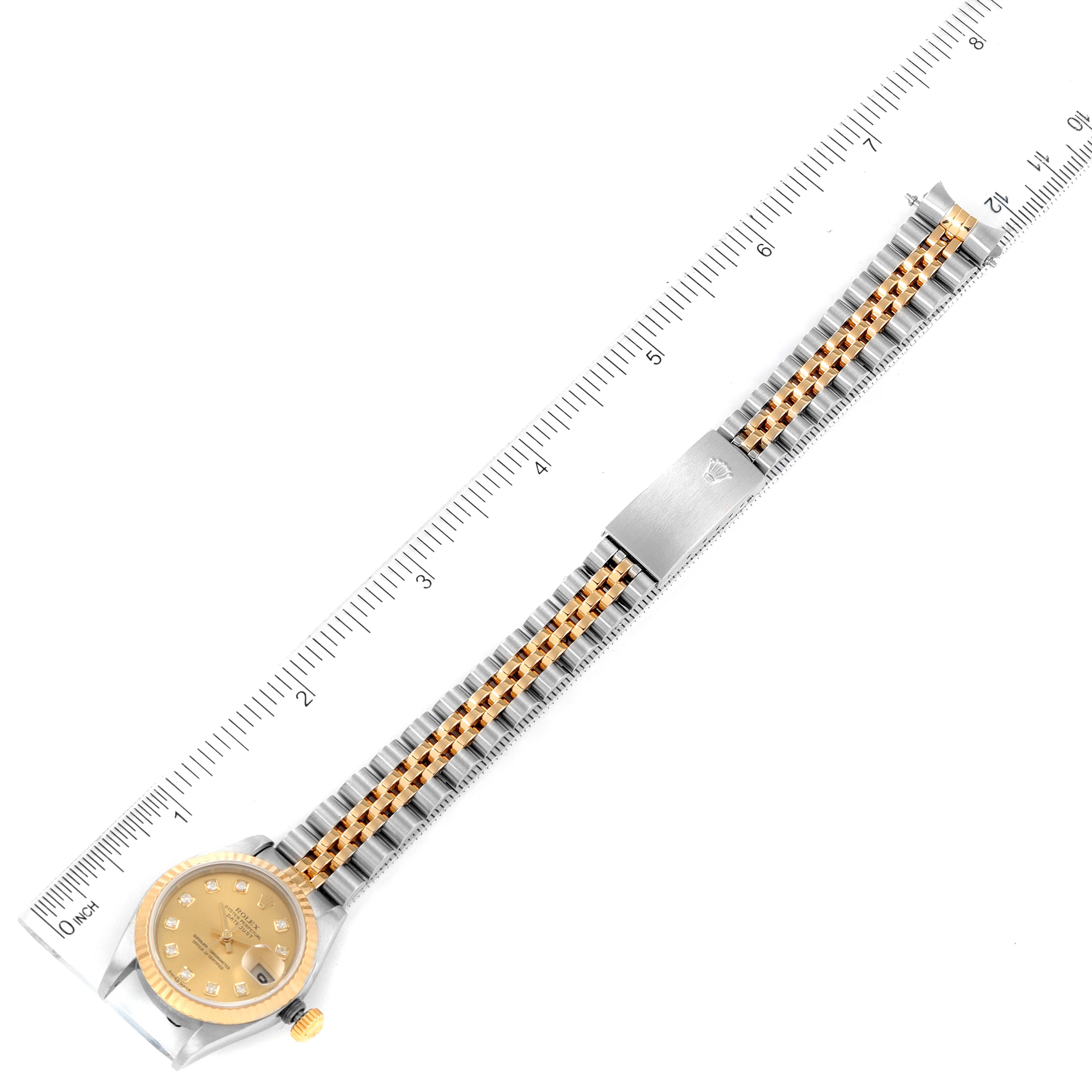 The watch is a Rolex Datejust 79173 Women's Steel and Gold (two tone) Champagne Dial 79173 Women's Steel and Gold (two tone) Champagne Dial model, shown from a top-down angle with its bracelet extended alongside a ruler.