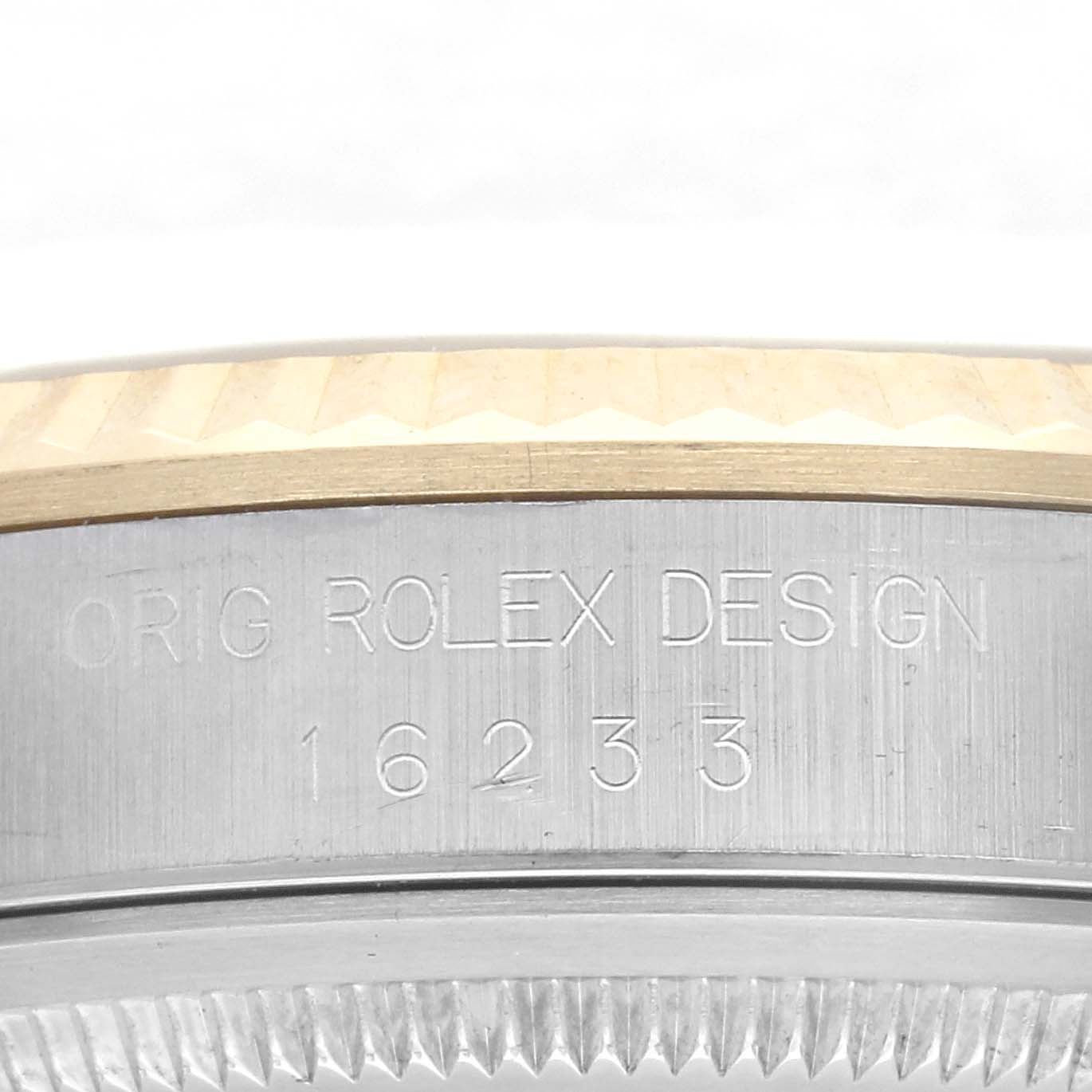 The image shows a side angle of the Rolex Datejust 16233 Men
s Steel and Gold (two tone) Champagne Dial 16233 Men
s Steel and Gold (two tone) Champagne Dial, focusing on the engraved model number and bezel details.