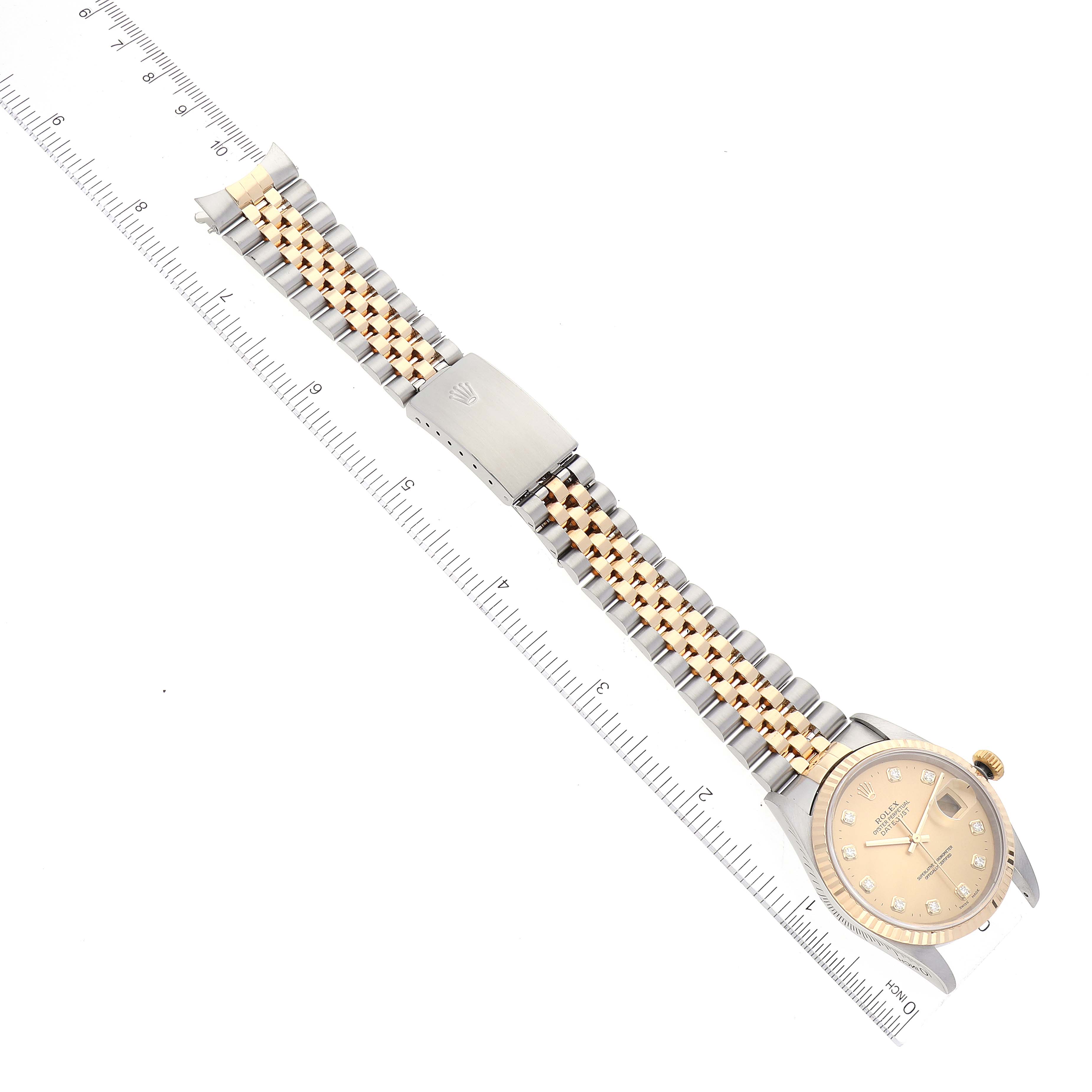 The image shows a Rolex Datejust 16233 Men's Steel and Gold (two tone) Champagne Dial 16233 Men's Steel and Gold (two tone) Champagne Dial watch laid flat, highlighting its face, two-tone bracelet, and clasp, with a ruler for scale.