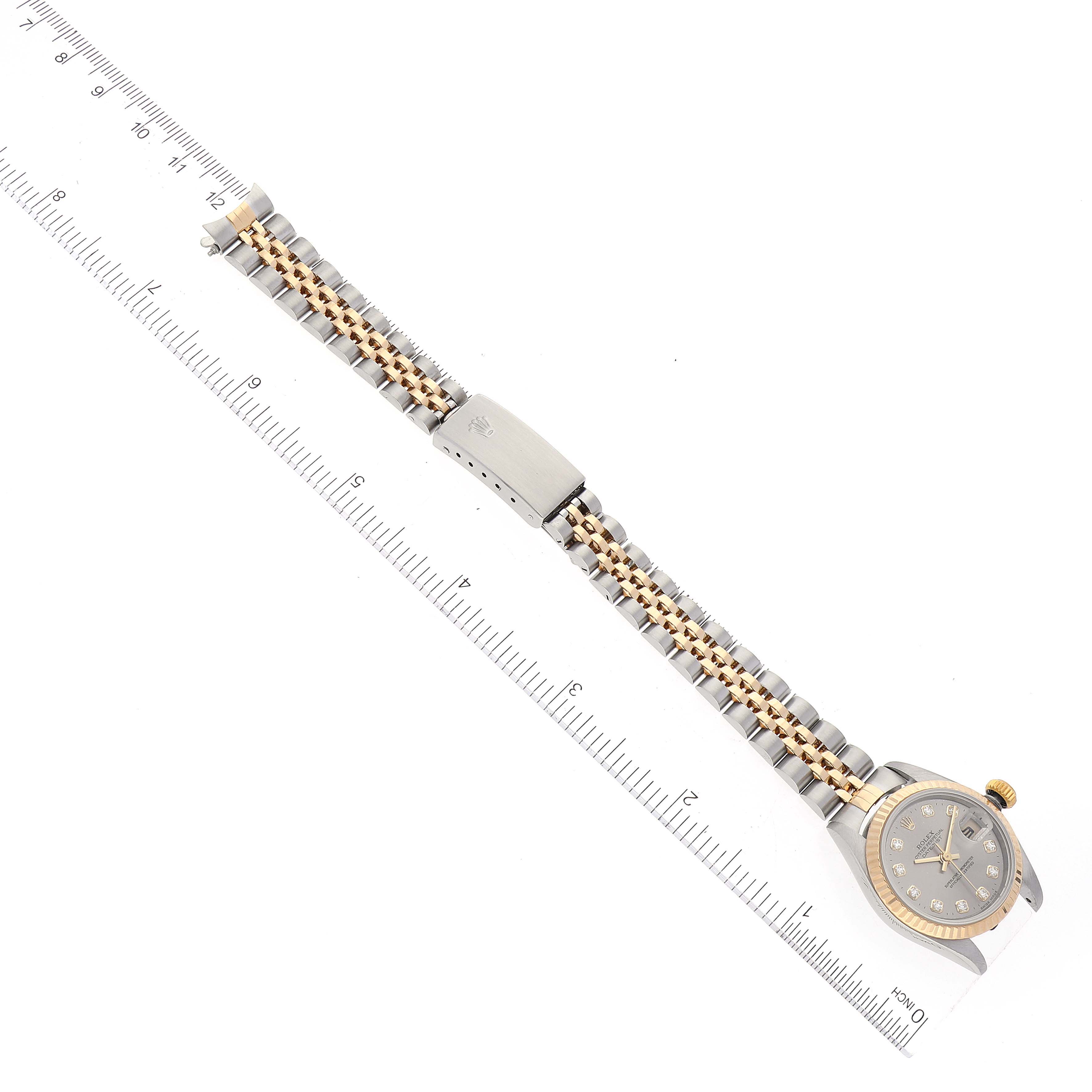 The Rolex Datejust 79173 Women's Steel and Gold (two tone) Grey Dial 79173 Women's Steel and Gold (two tone) Grey Dial watch is shown laid flat with its face, band, and clasp visible, alongside a measuring ruler.