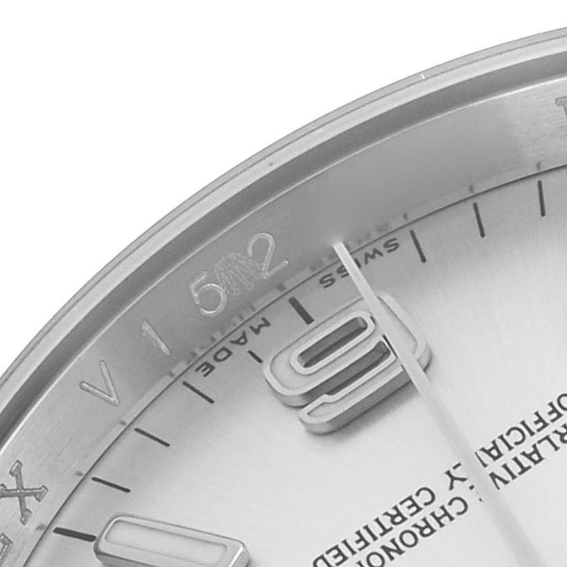 The image shows a close-up of the dial corner with hour markers and part of the bezel of a Rolex Oyster Perpetual 116000 Men's Stainless Steel Silver Dial 116000 Men's Stainless Steel Silver Dial watch.