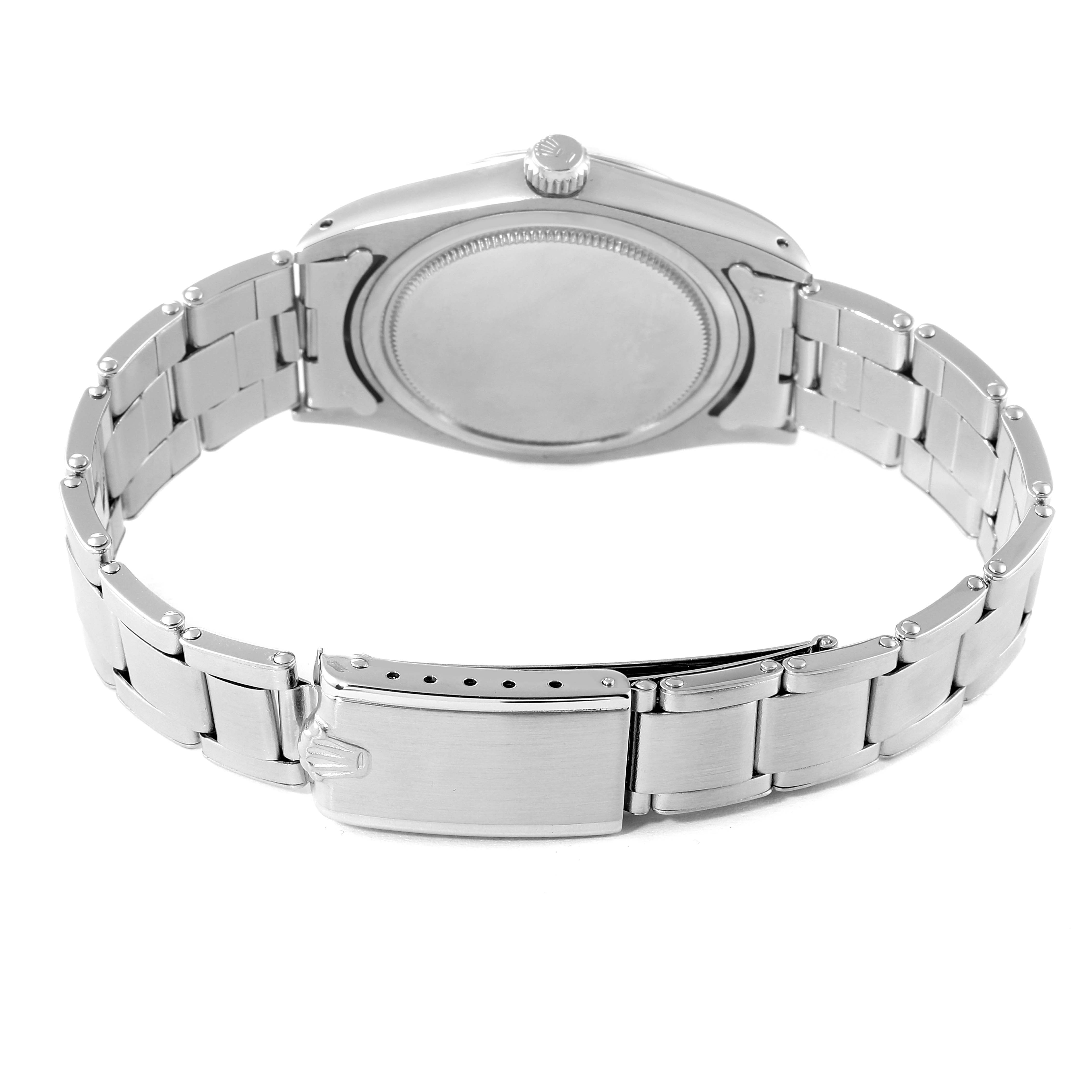 The Vintage Collection Rolex watch is shown from the back, displaying its caseback and metal bracelet.