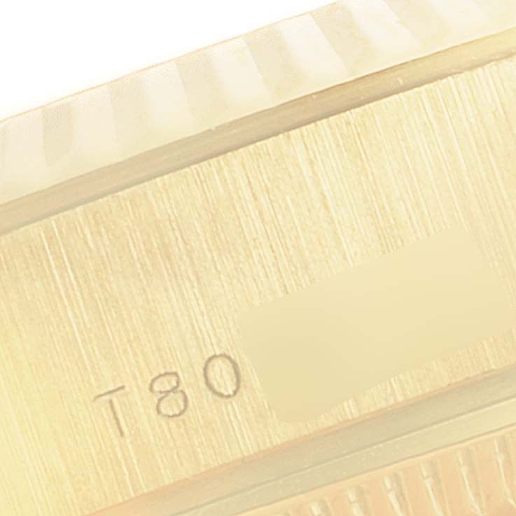 This is a close-up of the bezel and case side of a Rolex President 69178 Women's Yellow Gold White Dial 69178 Women's Yellow Gold White Dial model watch, showing some engraved markings.