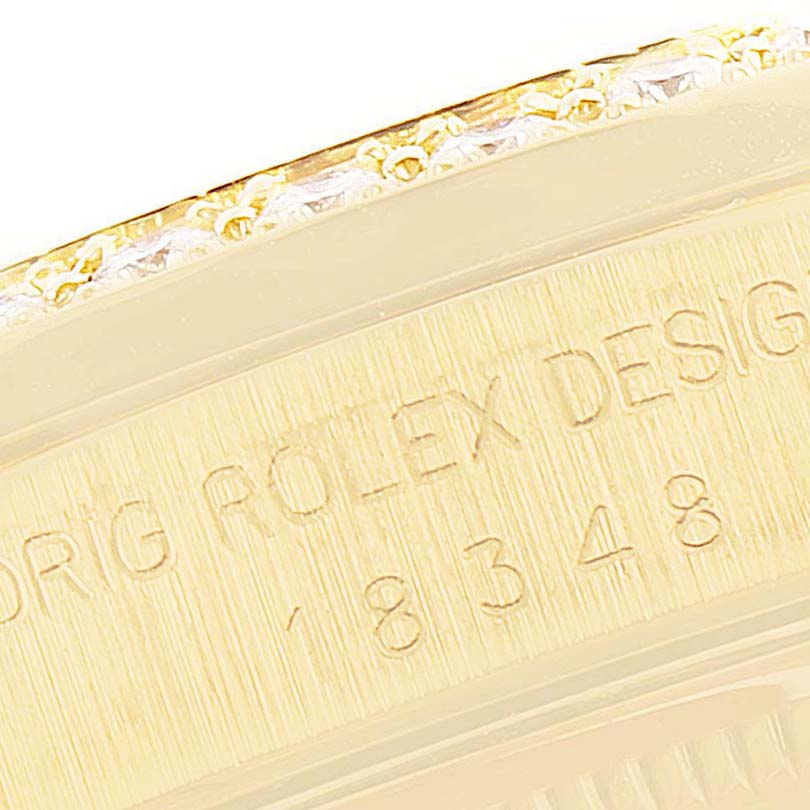 This image shows a close-up of the side of a Rolex President 18348 Men's Yellow Gold Champagne Dial 18348 Men's Yellow Gold Champagne Dial model watch, featuring part of the bezel and engraved details.