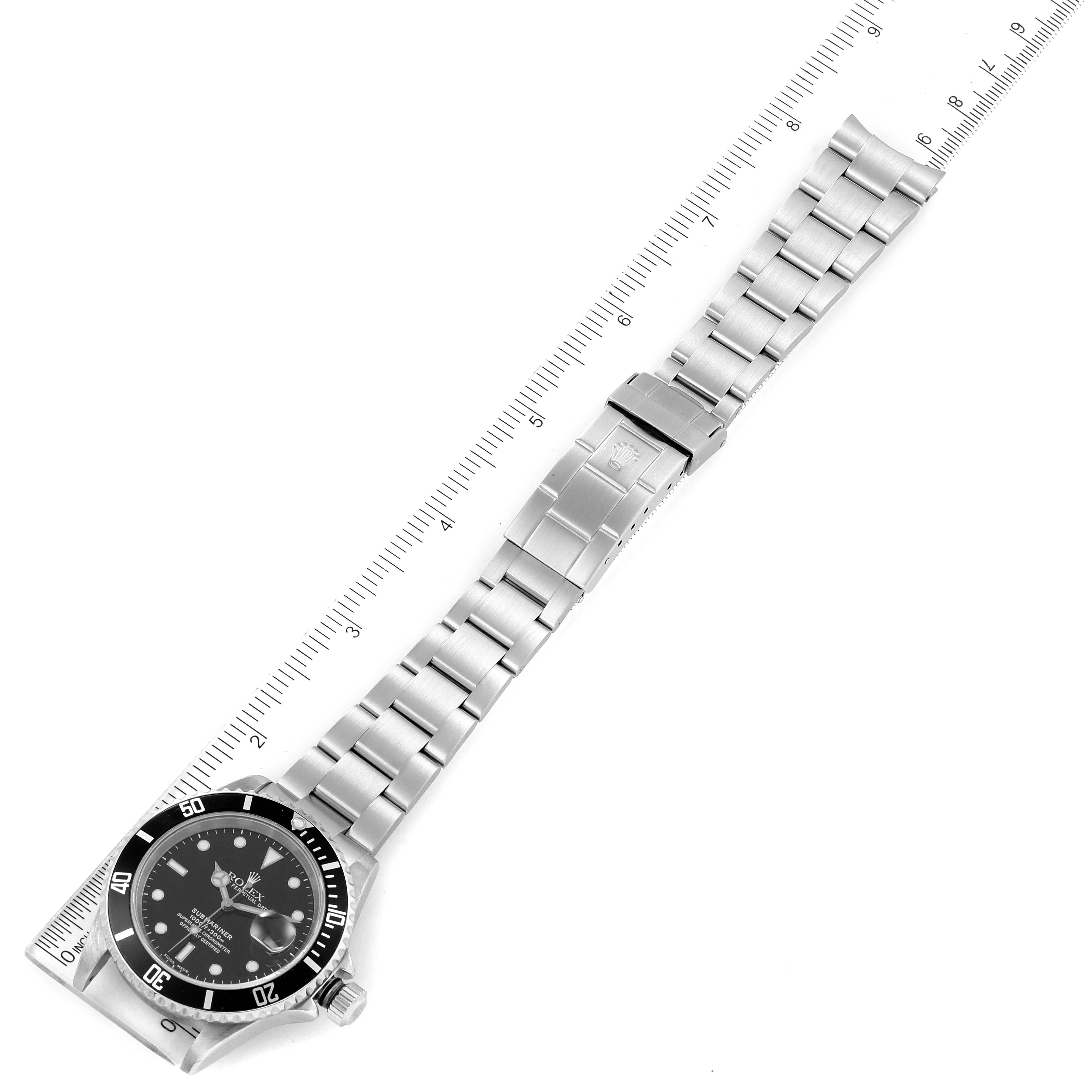 The image shows a Rolex Submariner 16610 Men's Stainless Steel Black Dial 16610 Men's Stainless Steel Black Dial watch from a top-down angle, displaying the entire watch bracelet alongside a measuring ruler.