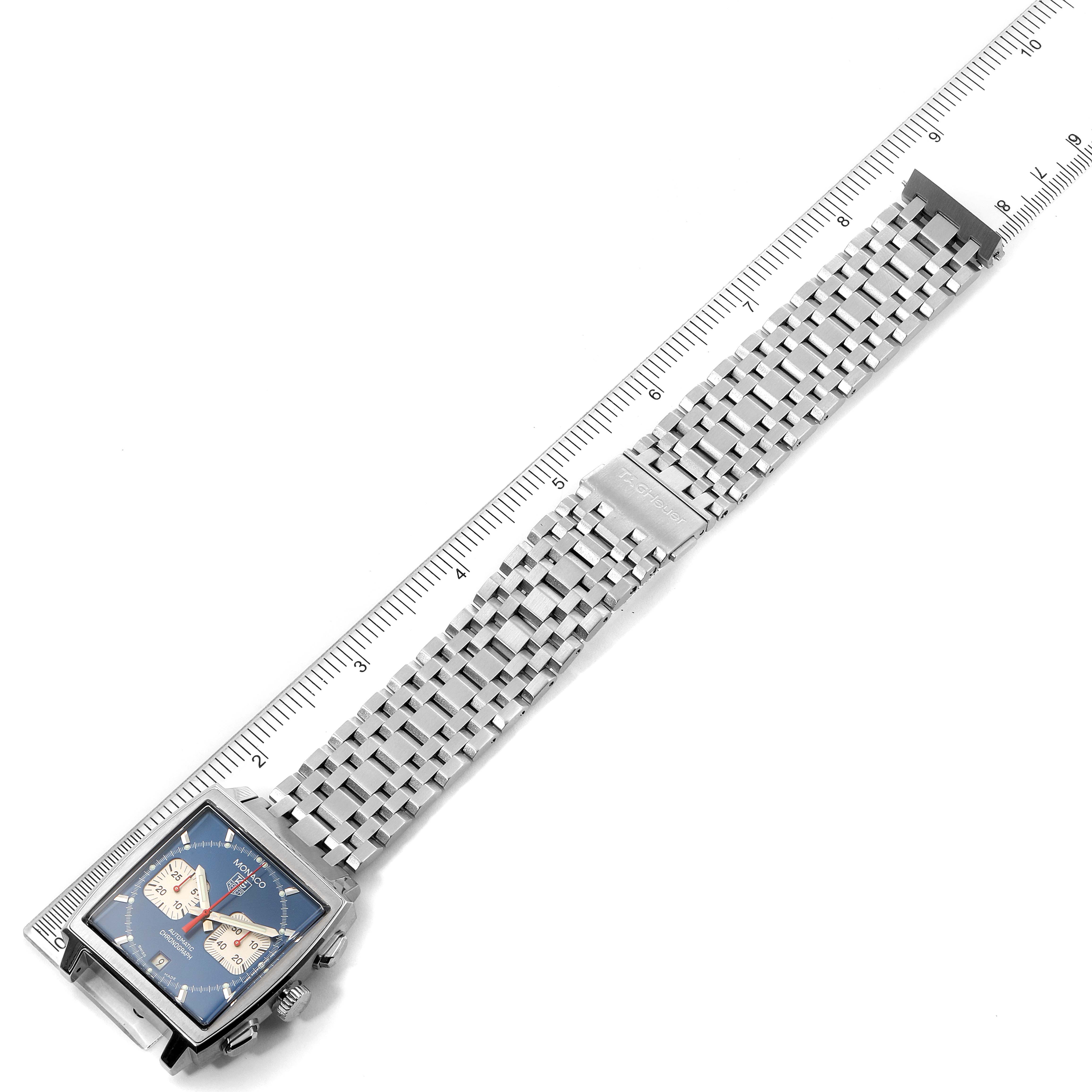 The image shows a top-down view of a Tag Heuer Monaco CW2113.BA0780 Men's Stainless Steel Blue Dial CW2113.BA0780 Men's Stainless Steel Blue Dial watch with a metal bracelet and clasp, alongside a ruler for scale.