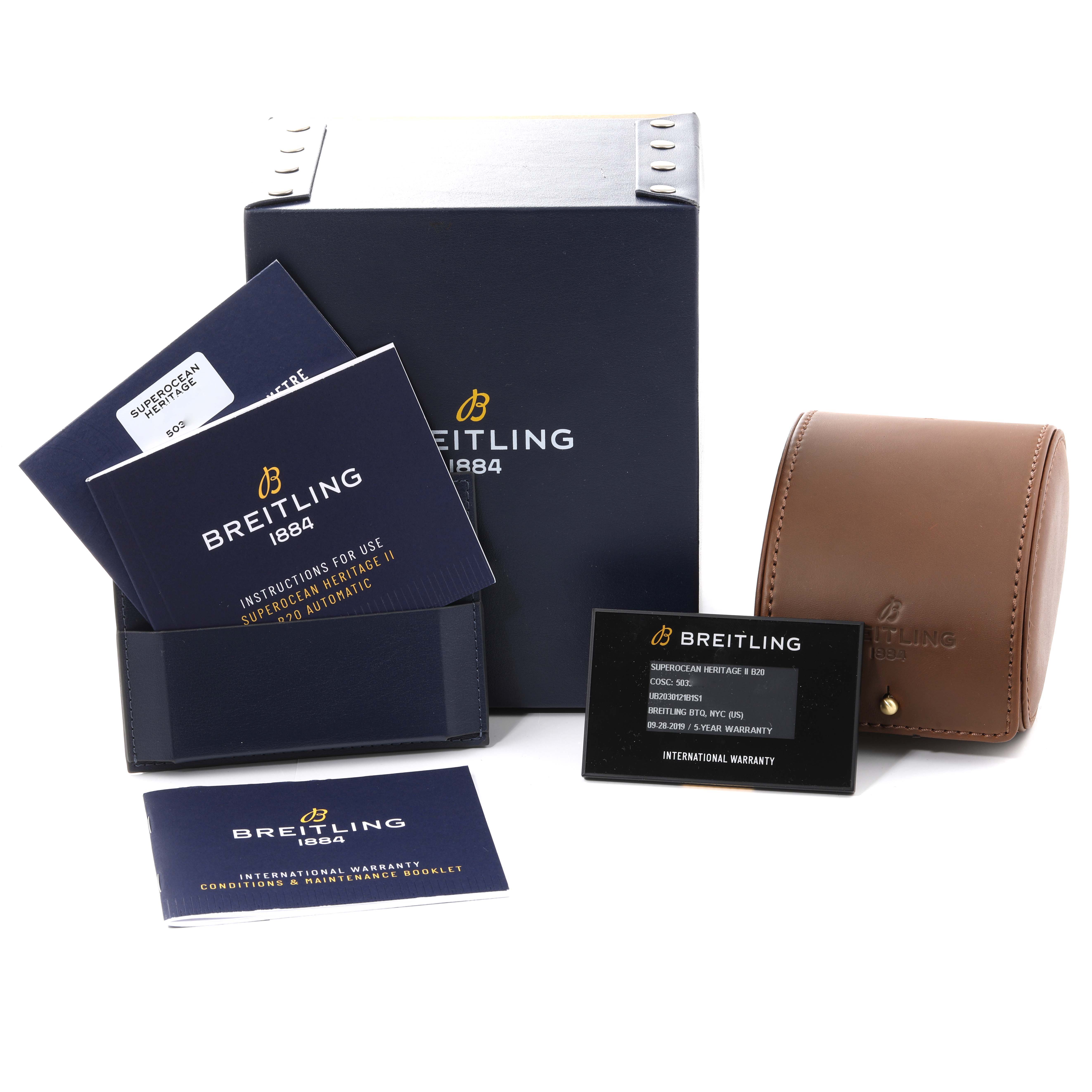 The image shows the packaging, manuals, warranty card, and a leather travel case for the Breitling Superocean UB2030121B1S1 Men's Steel and Gold (two tone) Black Dial UB2030121B1S1 Men's Steel and Gold (two tone) Black Dial watch, displayed at an angle.