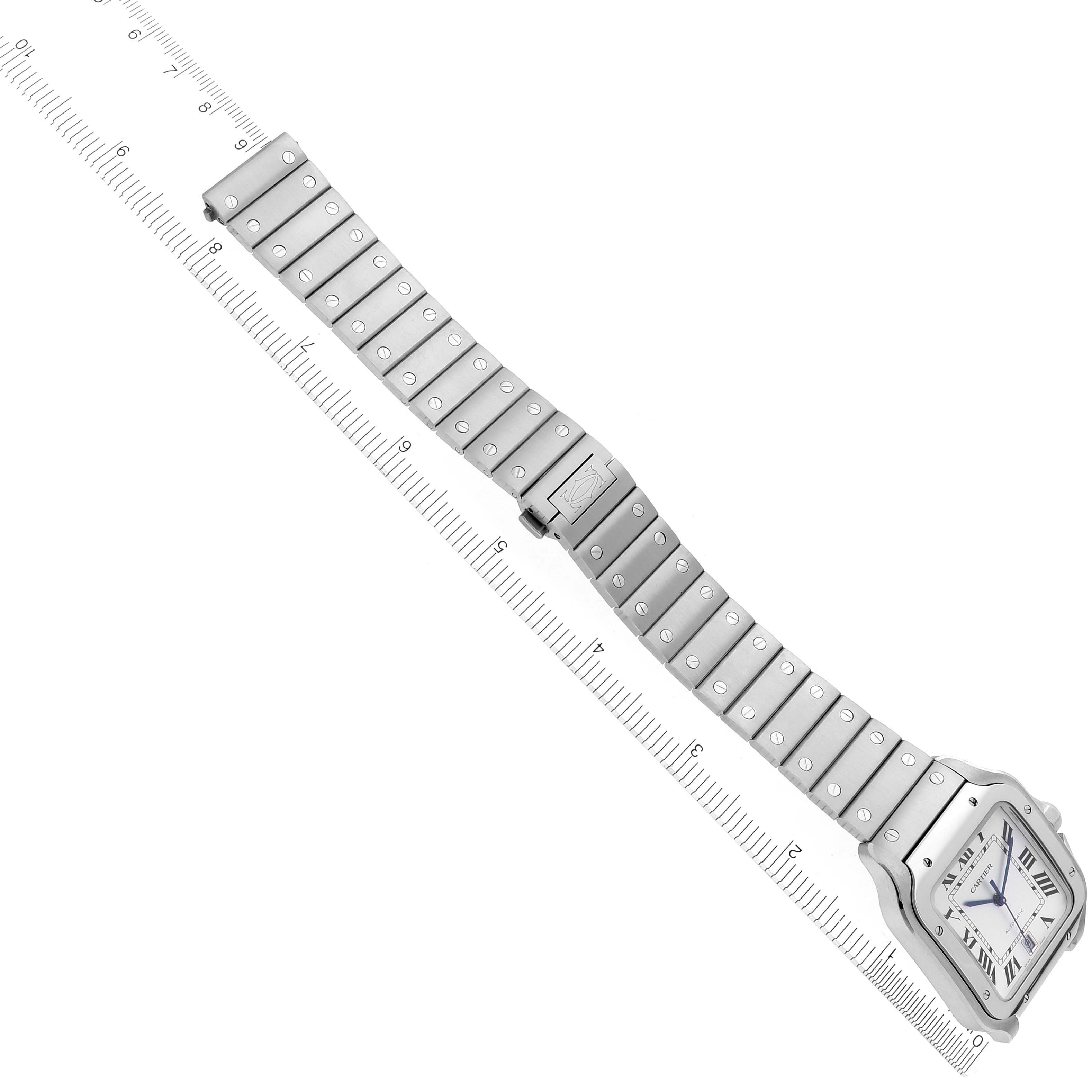 The image shows a Cartier Santos WSSA0018 Men's Stainless Steel Silver Dial WSSA0018 Men's Stainless Steel Silver Dial watch from a top-down angle, with a clear view of the face and metal bracelet fully extended alongside a ruler.