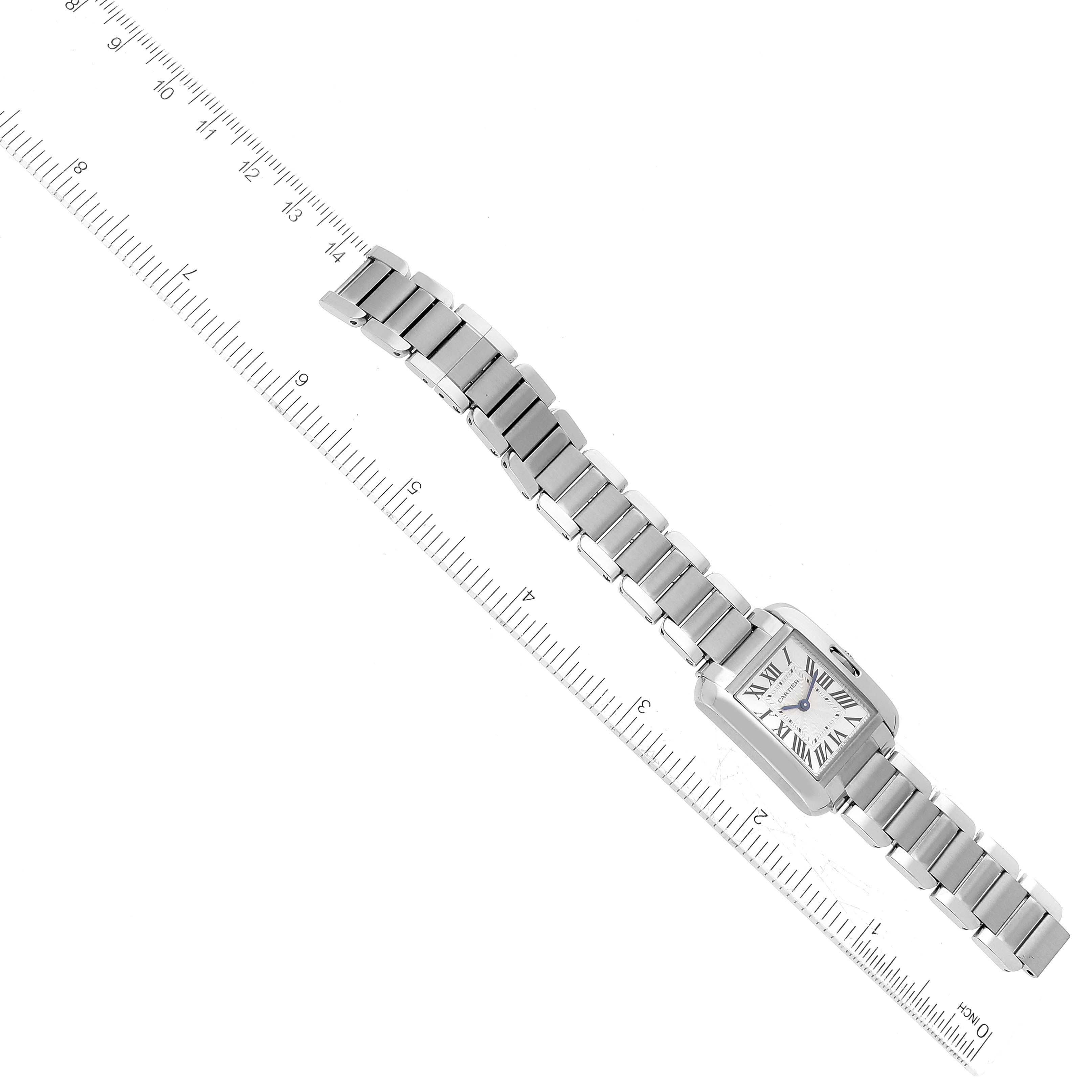 The image shows the front view of a Cartier Tank Anglaise W5310022 Women's Stainless Steel Silver Dial W5310022 Women's Stainless Steel Silver Dial watch with its metal bracelet fully extended next to a ruler.