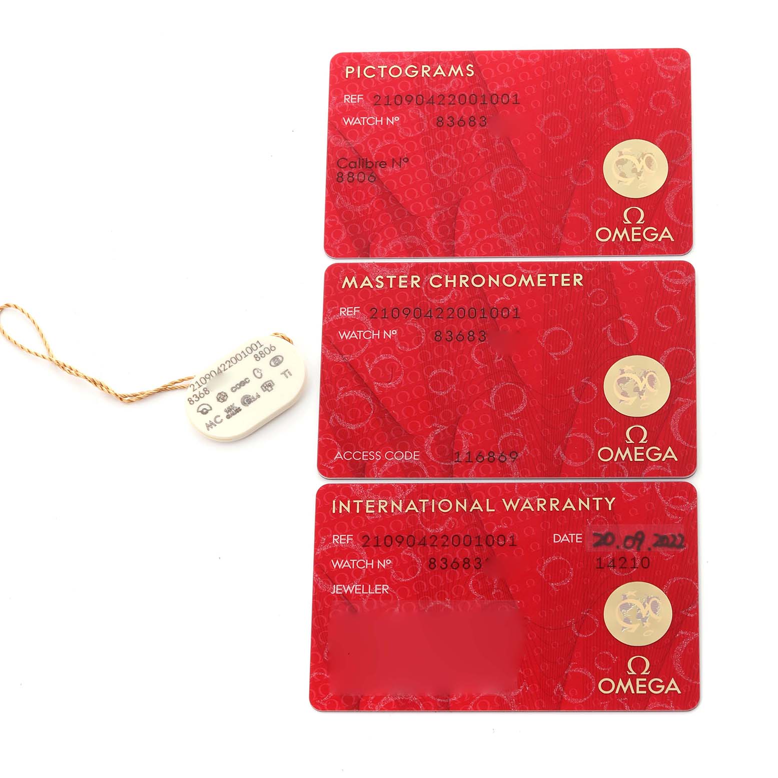 The image shows warranty and certification cards for an Omega Seamaster 210.90.42.20.01.001 Men's Titanium Brown Dial 210.90.42.20.01.001 Men's Titanium Brown Dial watch, along with a white tag.