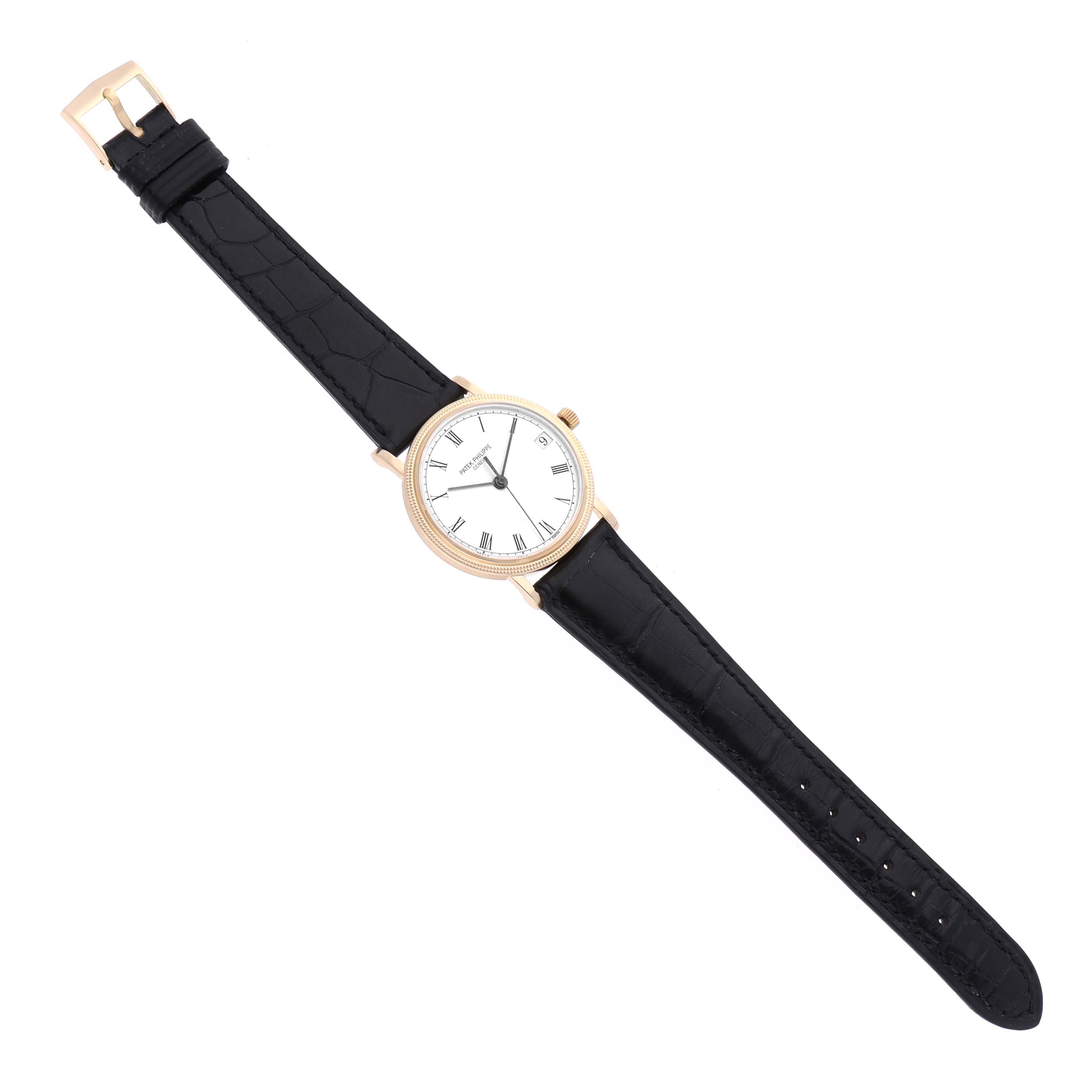 The Patek Philippe Calatrava 3802/200 Men's Yellow Gold White Dial 3802/200 Men's Yellow Gold White Dial watch is shown from a top-down angle, featuring its face, bezel, and black leather strap.