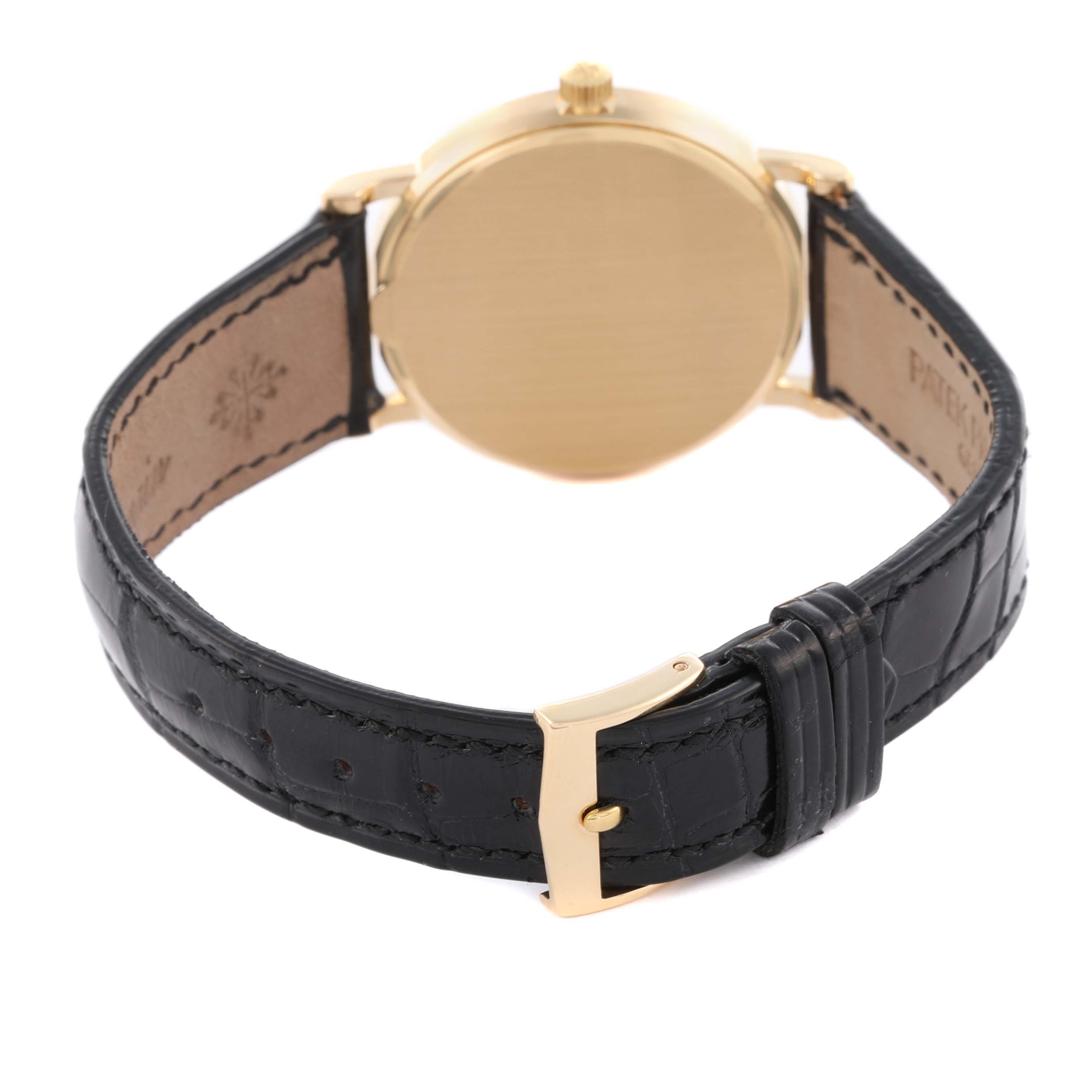 The image shows the back of a Patek Philippe Calatrava 3802/200 Men's Yellow Gold White Dial 3802/200 Men's Yellow Gold White Dial watch, highlighting the gold case and black leather strap with a gold buckle.