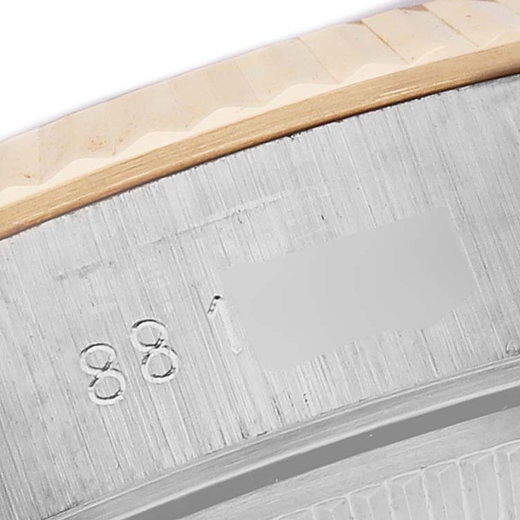 This close-up shows part of the engraved bezel of a Rolex Date 69173 Women
s Steel and Gold (two tone) White Dial 69173 Women
s Steel and Gold (two tone) White Dial model.