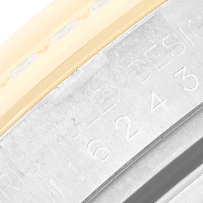 This close-up shows the bezel and part of the case of a Rolex Datejust 116243 Men's Steel and Gold (two tone) Black Dial 116243 Men's Steel and Gold (two tone) Black Dial watch.