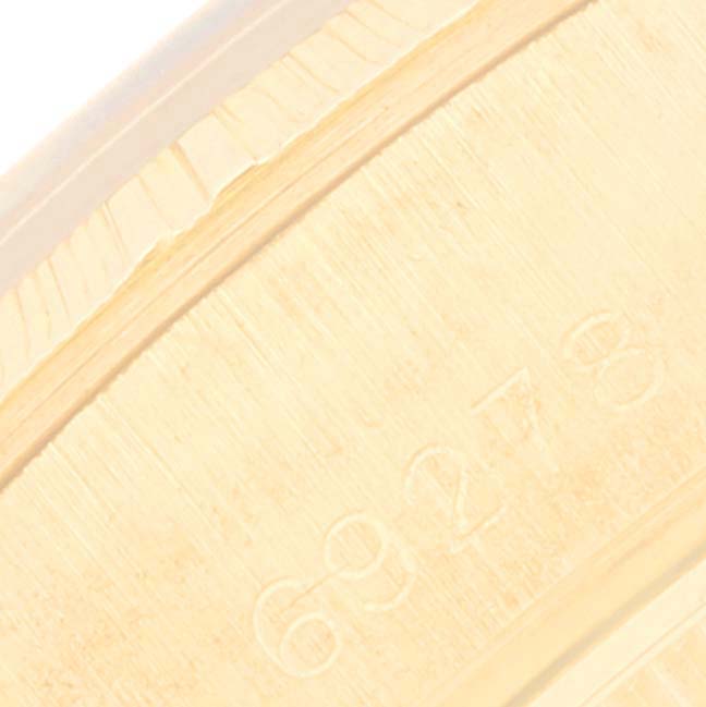 The image shows a close-up angle of the outer edge of the case of a Rolex Datejust 69278 Women's Yellow Gold Black Dial 69278 Women's Yellow Gold Black Dial watch, highlighting the engraved serial number.