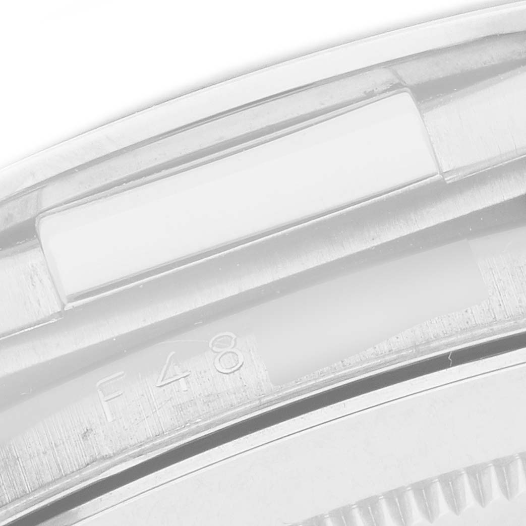 The image shows a close-up of the edge and serial engraving on a Rolex Daytona 116519 Men's White Gold Silver Dial watch, focusing on the bezel and case.